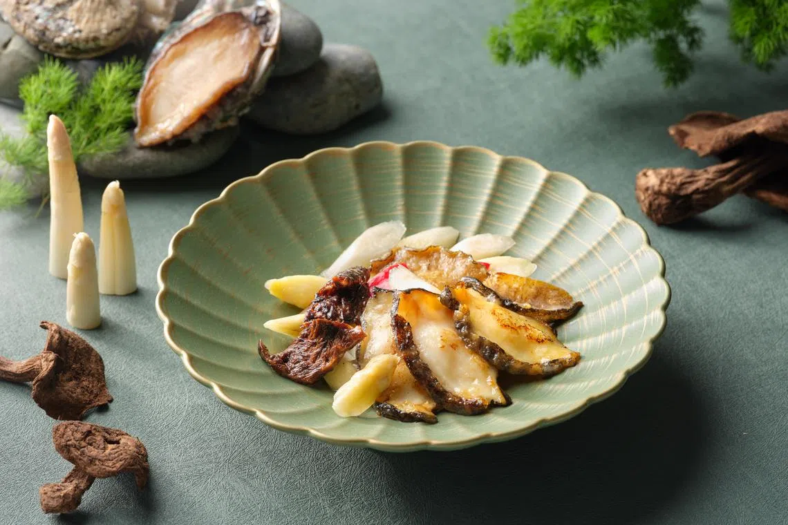 四川豆花饭庄的黑虎掌白芦笋炒南非活鲜鲍鱼片，是食材丰富的创意之作。（餐馆提供）