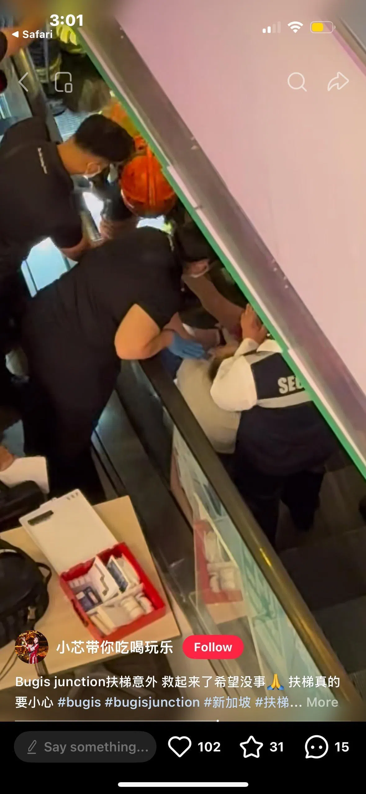 民防部队救护人员到场后在电动扶梯旁检查小女孩情况，消防员则尝试将女孩的右脚救出。（互联网）