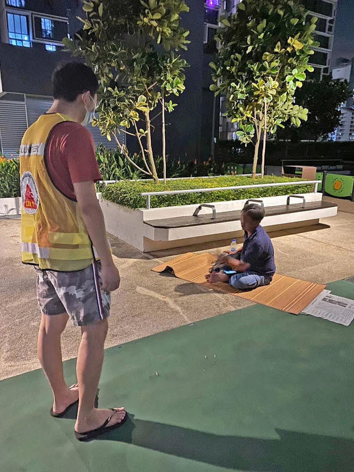 身穿荧光绿背心的巡逻员和席地而坐的公众对谈。（取自面簿）