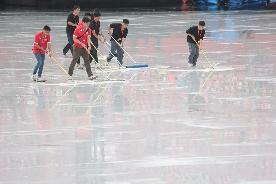 随着雨势转小，工作人员抓紧时间，清理表演区域的积水，确保庆典能准时开场。（李冠卫摄）