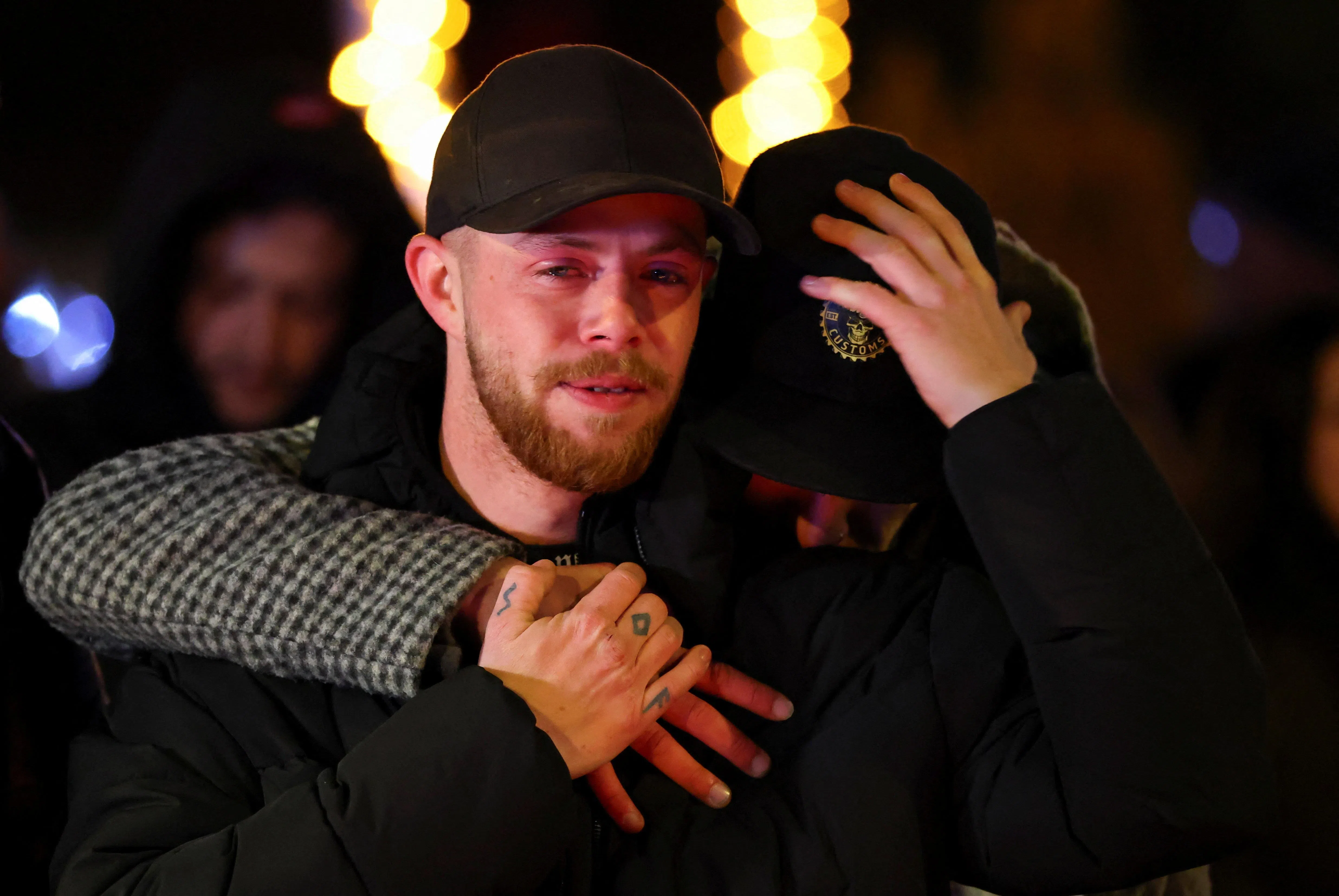 民众焦虑地在警方封锁线外等候亲友的消息。（路透社）