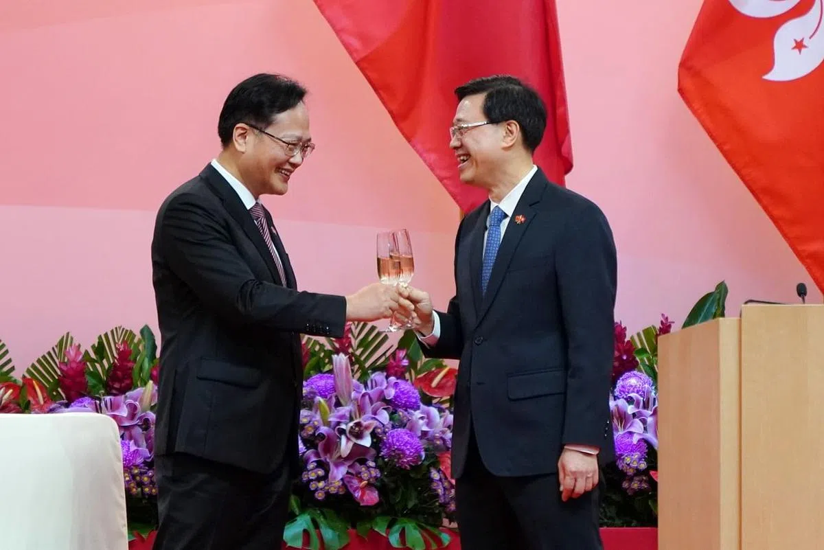 香港特首林郑月娥到北京出席中共建党100周年庆祝大会，署理特首李家超（右）与香港中联办副主任陈冬昨天在香港特区成立24周年酒会上相互祝酒。 （中新社）