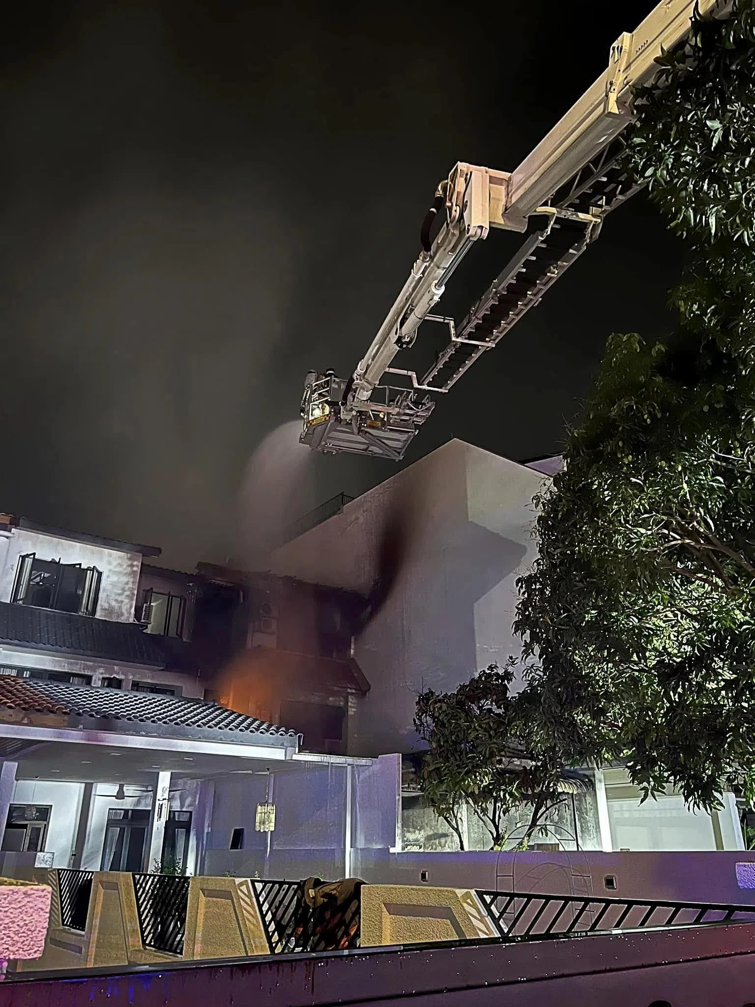 民防部队出动云梯从高出洒水，协助扑灭火势。（取自新加坡民防部队脸书）