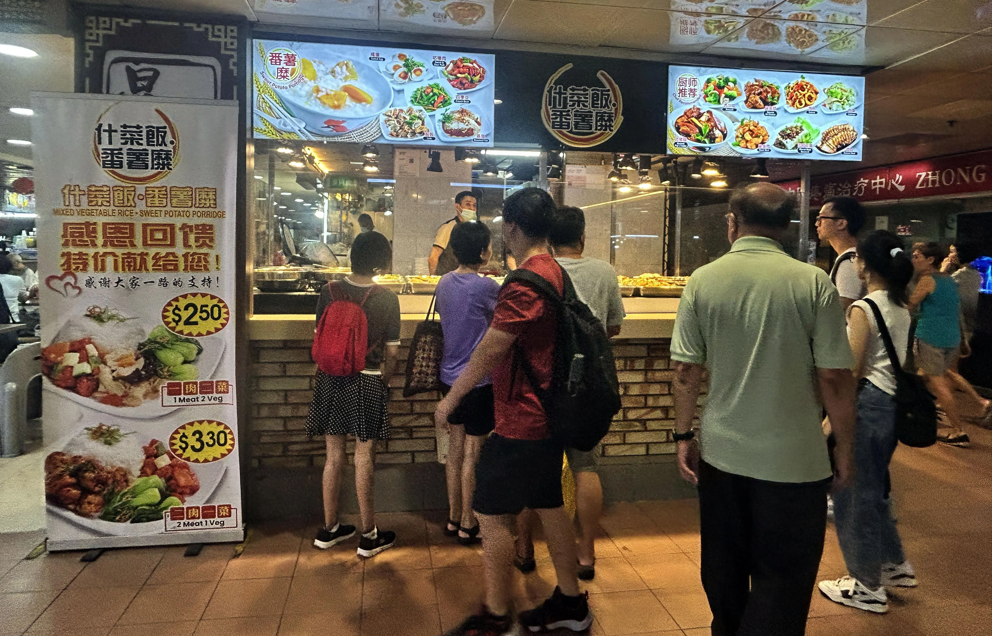 另一家杂菜贩摊位“什菜饭.番薯糜”，同样提供一肉两菜2.50元的优惠。（曾美玲摄）