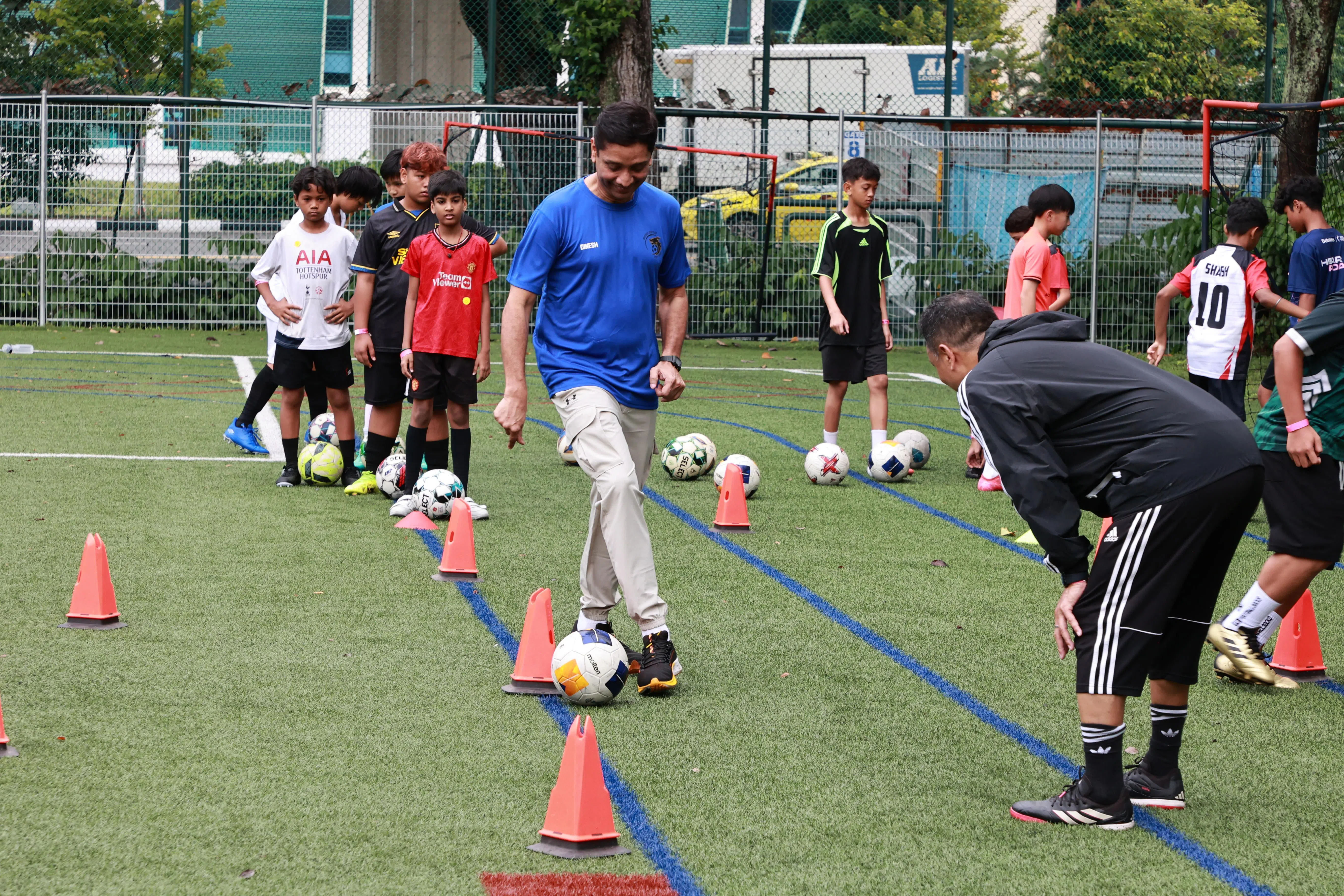东南区市长迪内希（蓝衣）也下场，和学生们一同参与训练，范迪阿末（黑衣）在旁指点。（周国威摄）