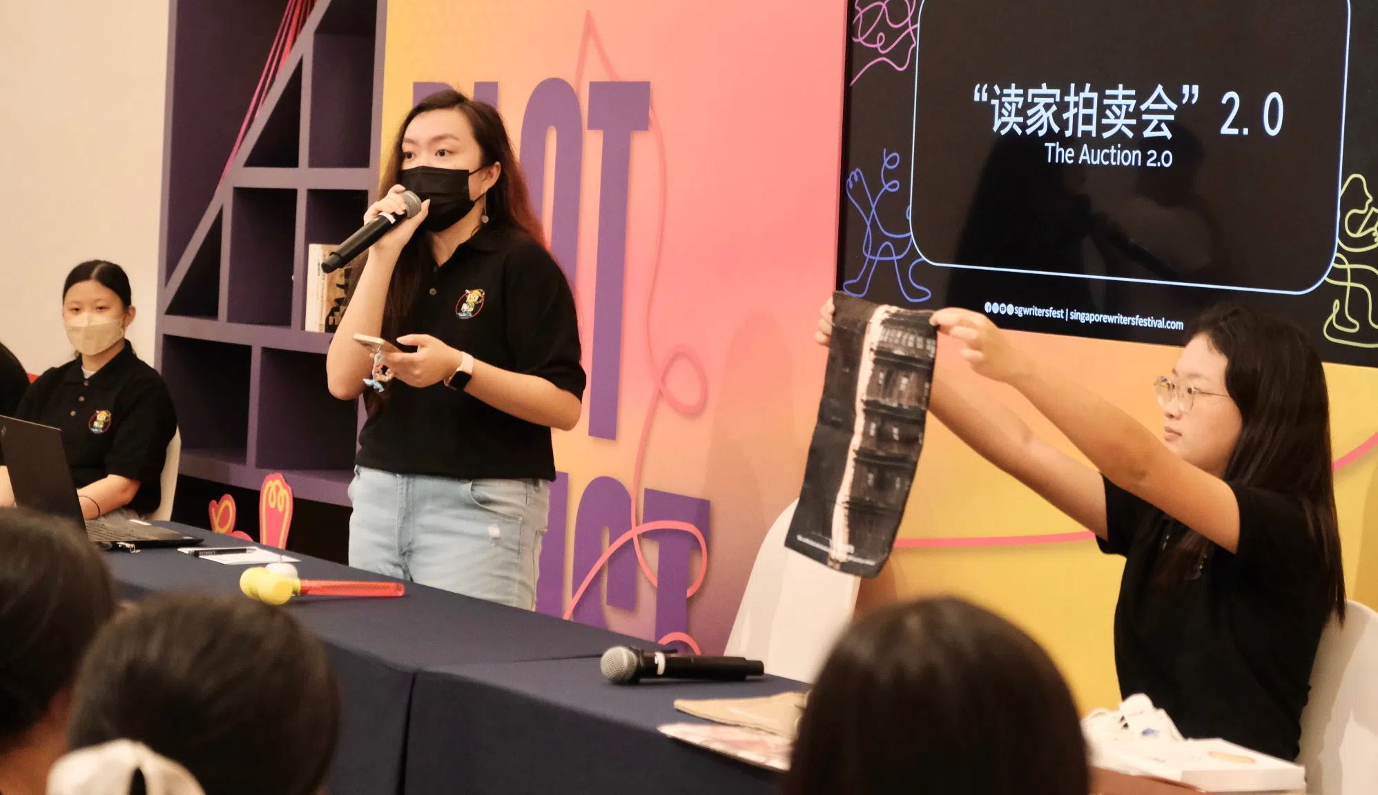 主持人周佳铃（中）为大家介绍拍卖会的第一件拍品。（张菲扬摄）