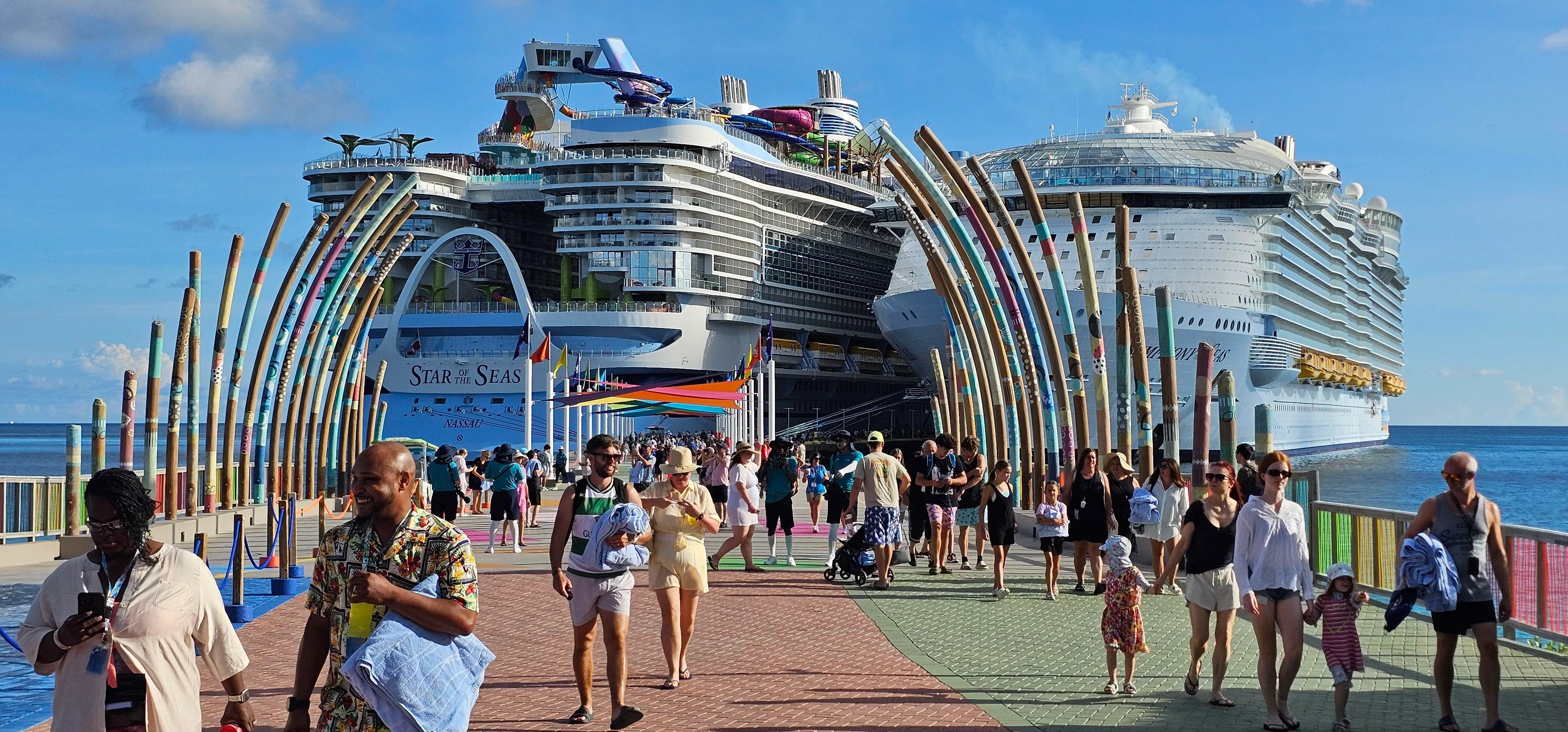 全新的“海洋之星号”（左）停泊在Cococay（可可湾）的码头上，个头明显比“海洋交响号”高处一个头。（刘嘉铿摄）