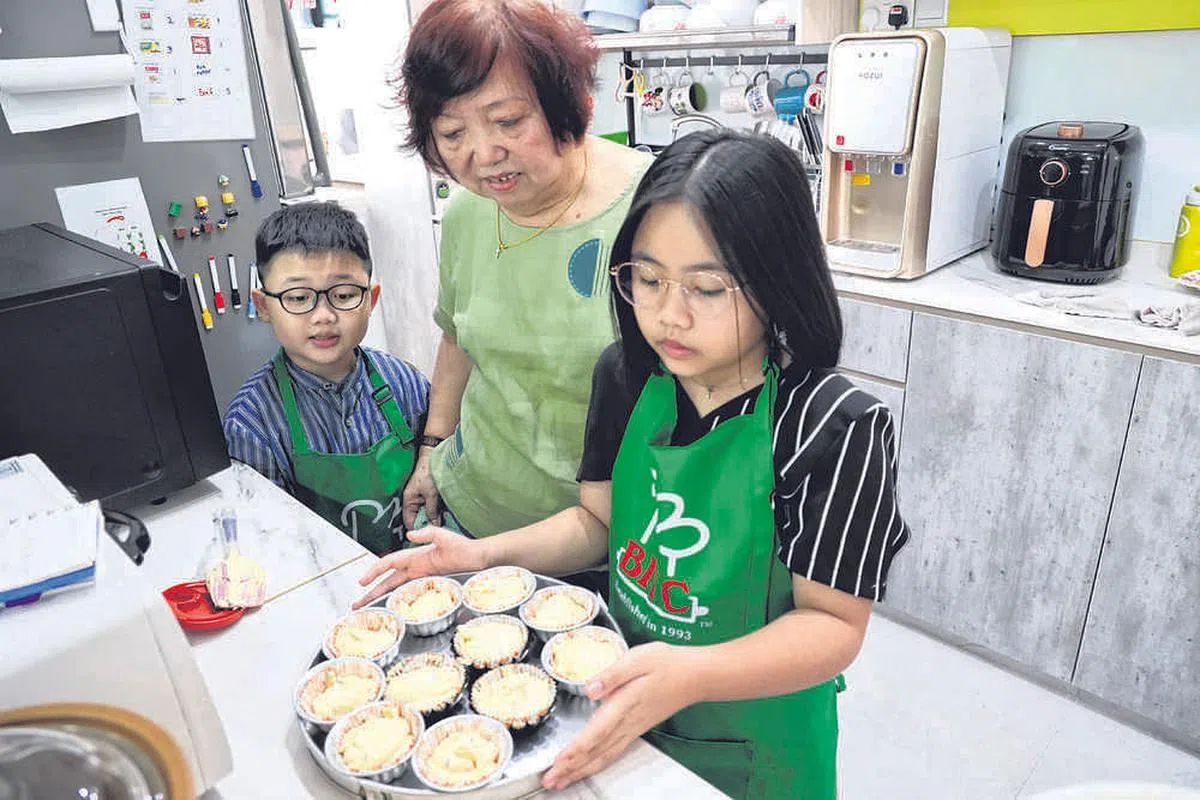外婆章翠娟擅长烘焙各种美味糕饼，祖孙三人有时会一起制作杯子蛋糕。（邝启聪摄）