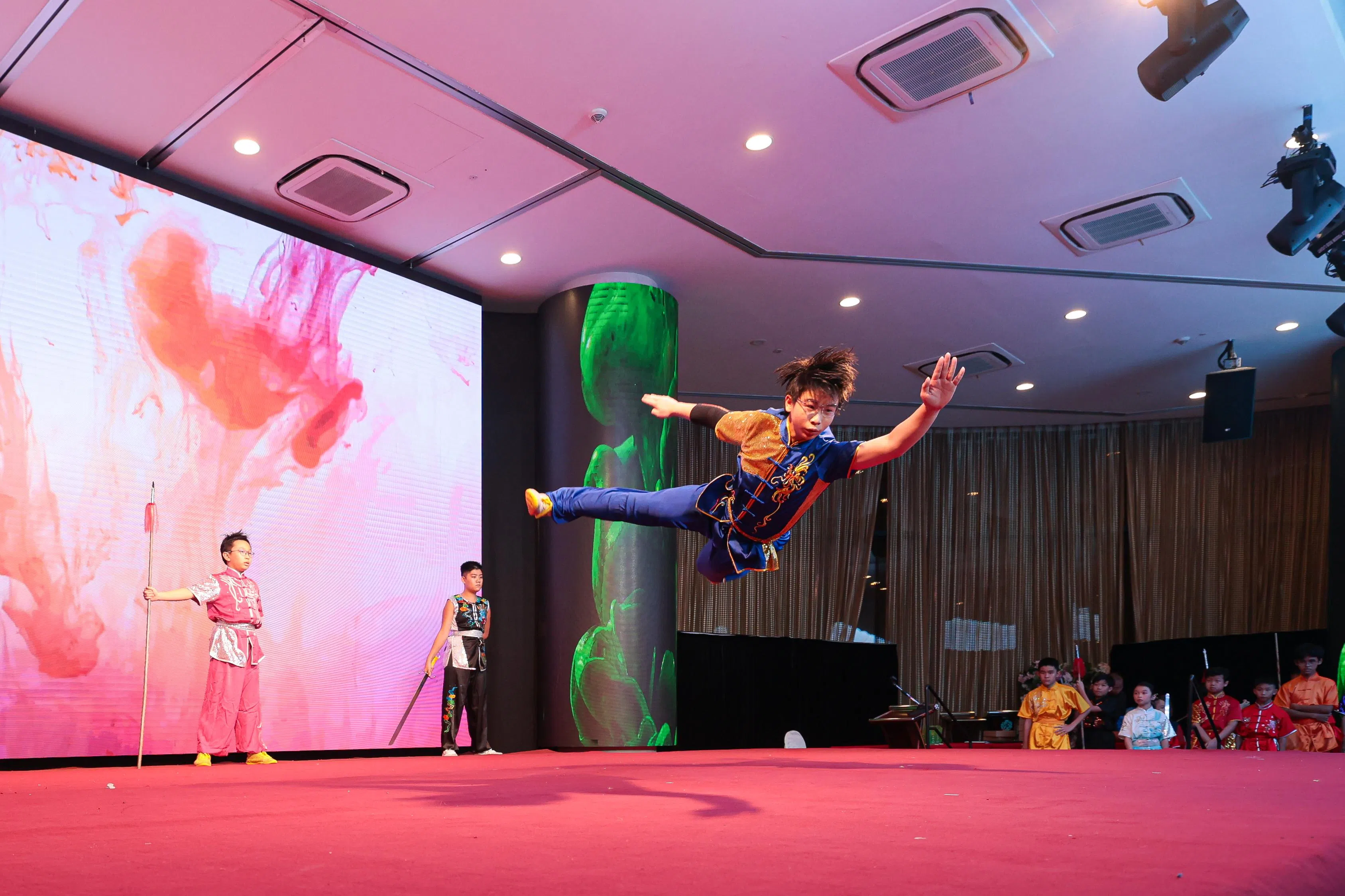 12岁的谢君隆表演武术动作“旋子”。（李冠卫摄）