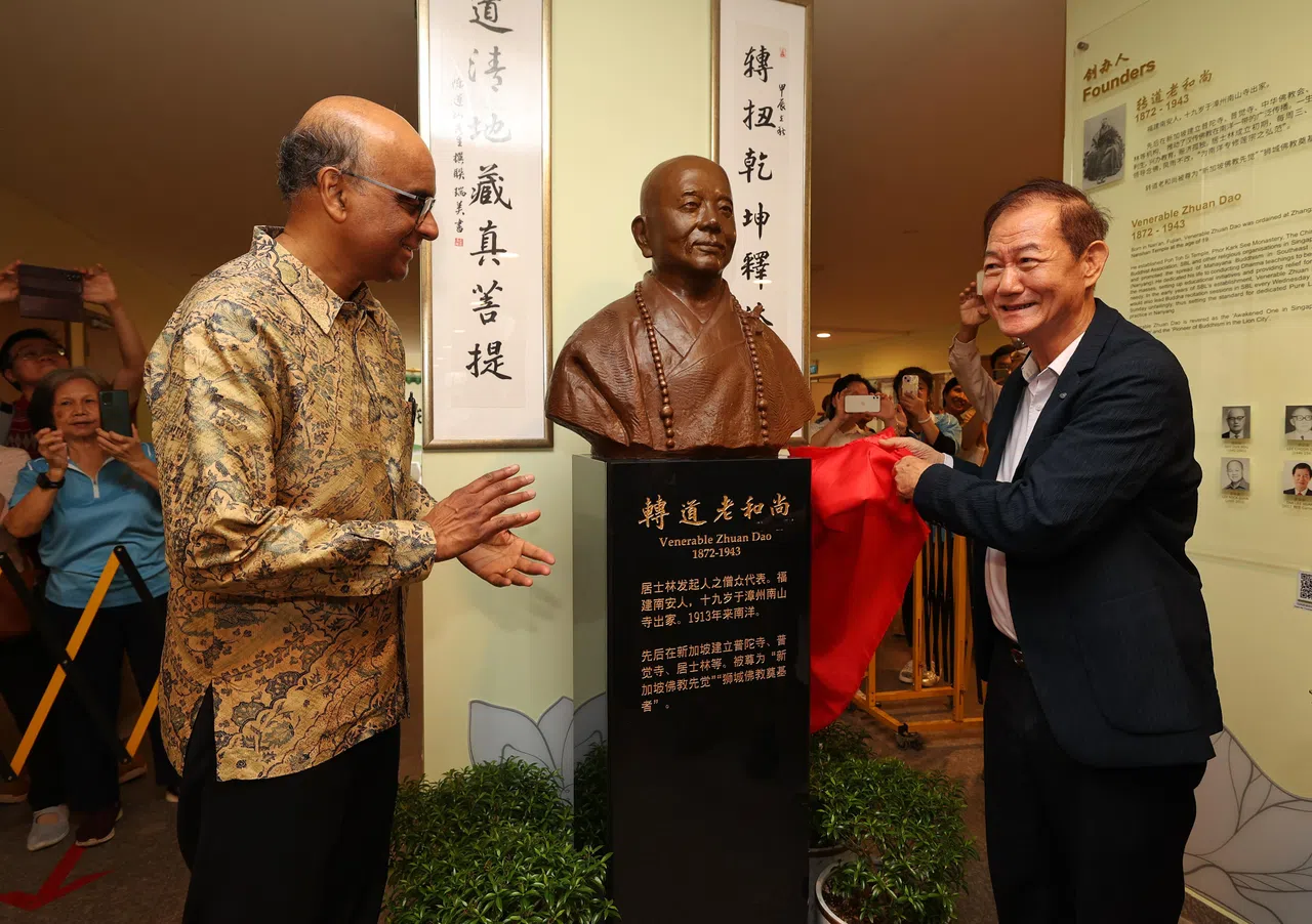 为了纪念90年来居士林六次搬迁与扩建，以及历届董事会、委员会成员和前贤的勤勉耕耘，居士林也在一楼入口处设立历史走廊，并为转道老和尚和李俊承居士两位创办人打造铜像，由尚达曼总统（左）和新加坡佛教居士林林长陈立发（右）一同进行铜像揭幕仪式。（唐家鸿摄）