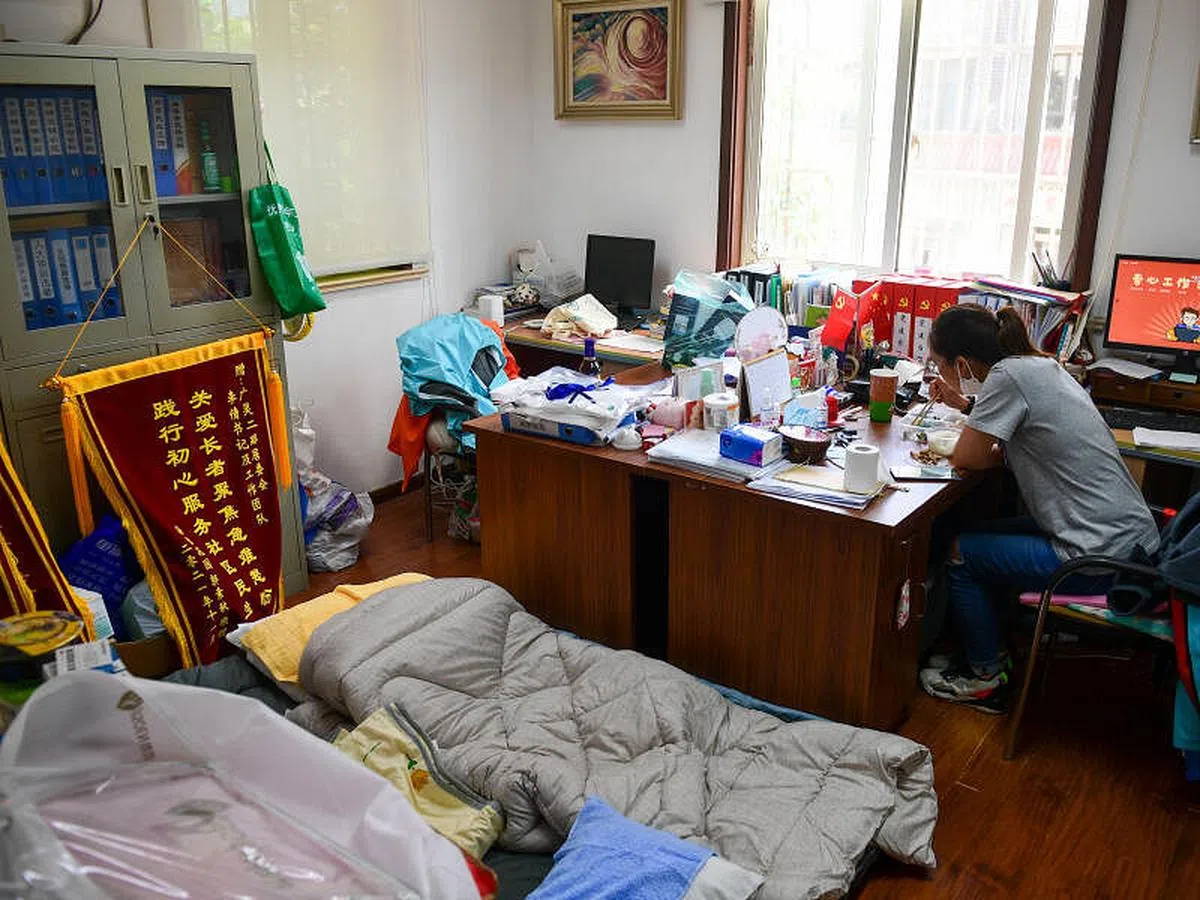 居委会人员工作强度相当大。图为上海虹口区一居民区党总支书记在办公室里吃盒饭。（中新社）