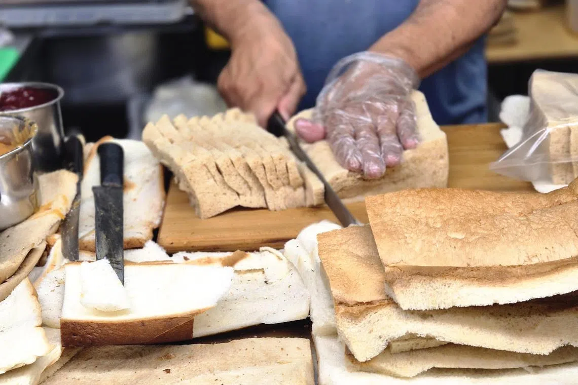 面包皮切掉后，再将中间柔软部分切片。（陈爱薇摄）