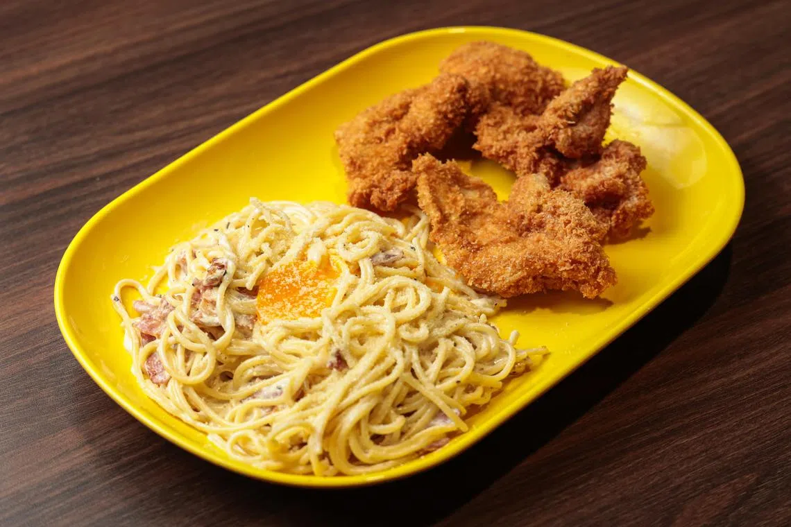 炸得香脆的鸡排，配上奶油培根酱意大利面，让人吃得心满意足。（李冠卫摄）