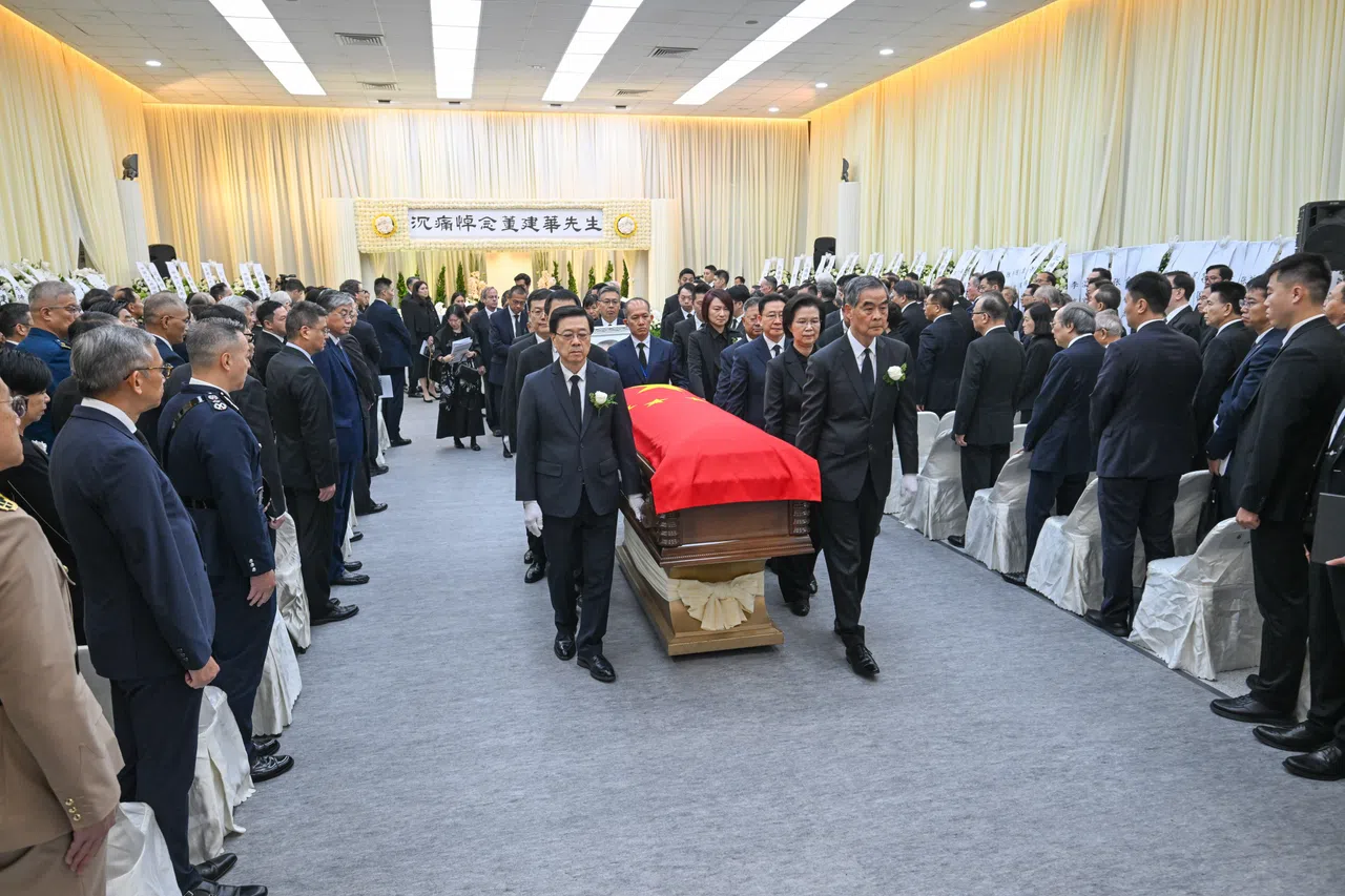 香港首任特首董建华9月8日逝世，公祭仪式星期天（9月20日）以国葬规格在香港殡仪馆举行。董建华的灵柩覆盖中国国旗，由全国政协副主席梁振英（前排右）、香港特首李家超（前排左）等人扶灵。（新华社）