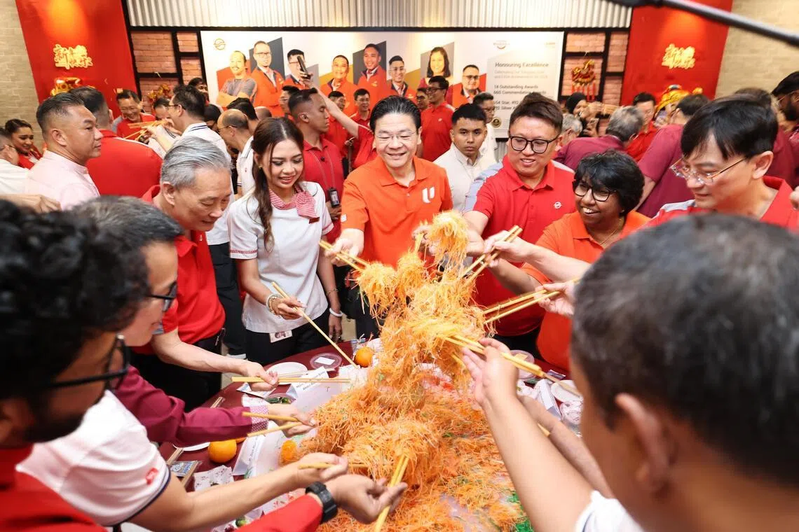 黄循财总理（中）在碧山车厂与工作人员一起捞鱼生，祝愿马年大吉大利、万事如意。（周国威摄）