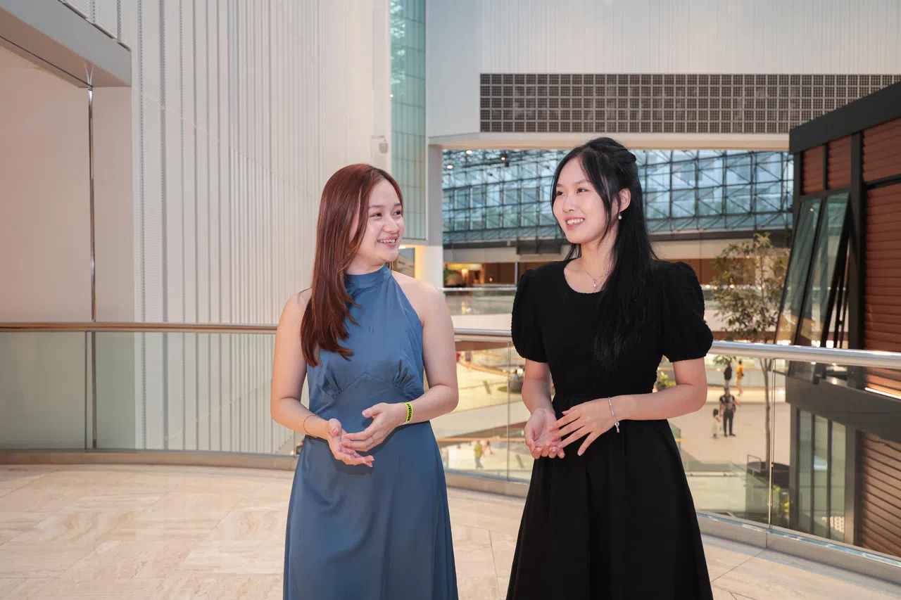 本地歌唱比赛的“熟面孔”蔡欣怡（25岁，图左）在谢师宴现场演绎《微光》。这首歌曲是2025年“新空下”新谣歌唱及创作比赛歌曲填词组冠军作品，也是新加坡艺术学院电影系的17岁学生张琪悦，想着自己中学生涯遇到的几位中文老师，感念他们指点人生迷津而创作的。（李冠卫摄）