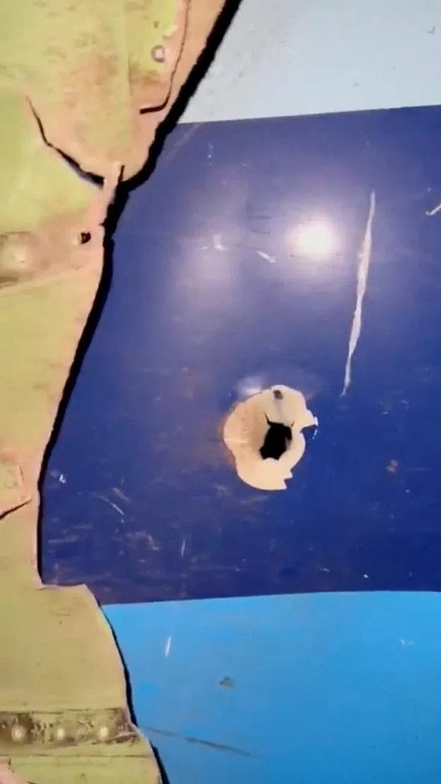 12月25日取自社交媒体的视频截图显示，失事客机机身有洞口，似被弹片击中。 （路透社）