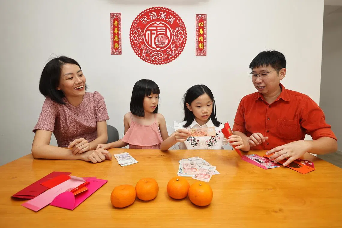 张美芳（左一）和林玉祥会与孩子一起开封红包，元宵节后再点算总额。（陈渊庄摄）