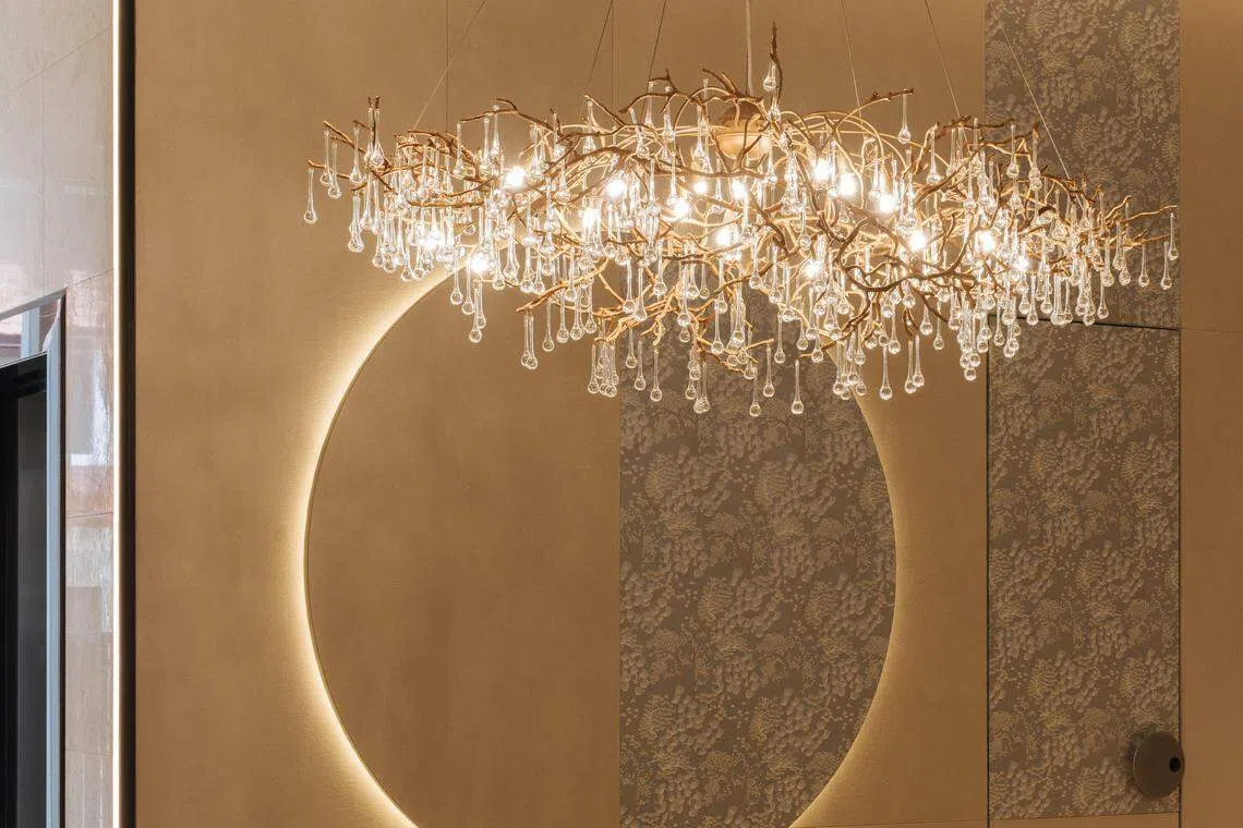 水晶灯有如云朵般，漂浮在覆布墙面的大圆圈设计“太阳”上端。（Metre Architects）