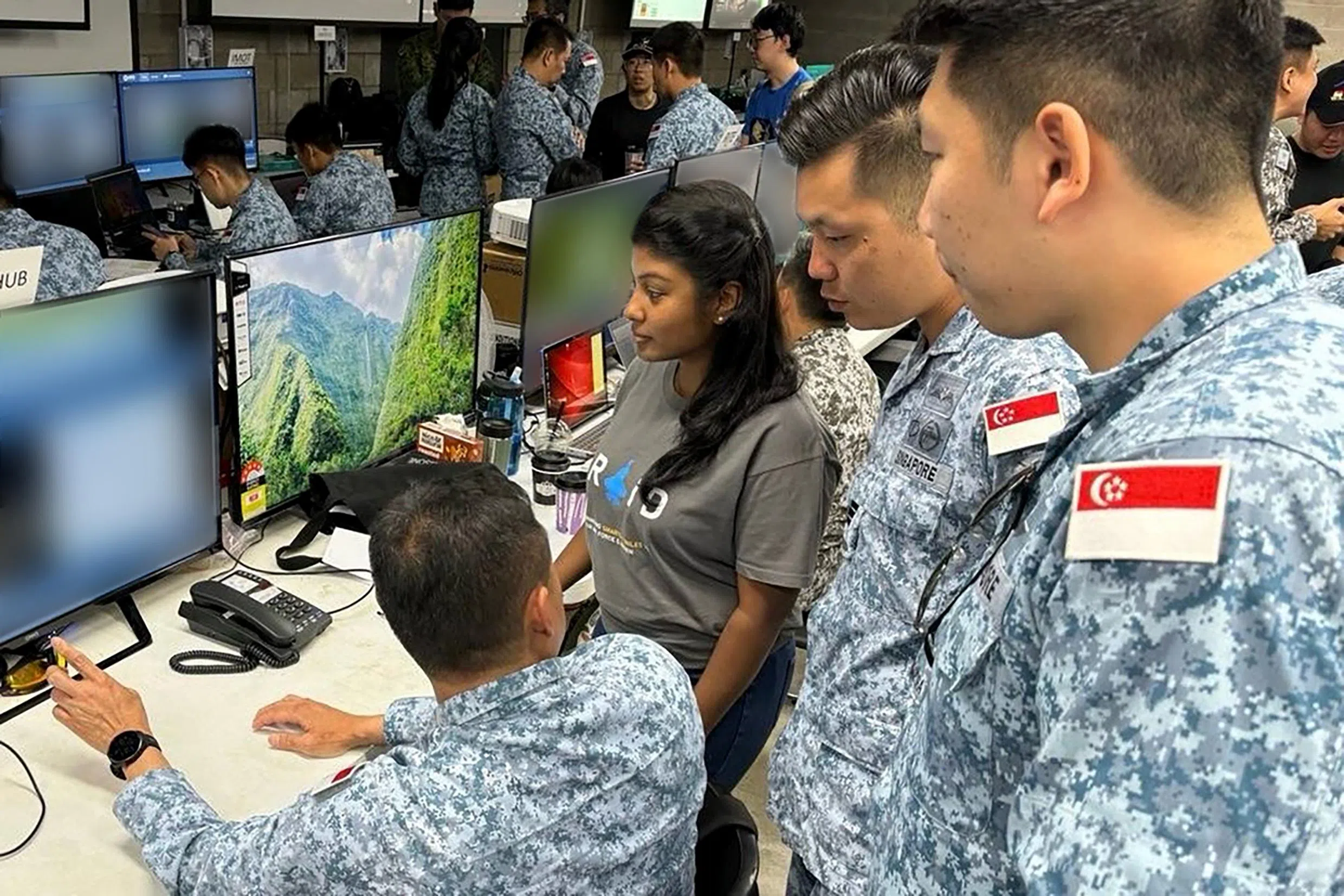 今年“袋鼠”演习期间，负责为流动影像情报传送系统进行升级的锐翼软件工程师薇雅（右三）与空军人员在指挥所展开讨论。（国防部提供）