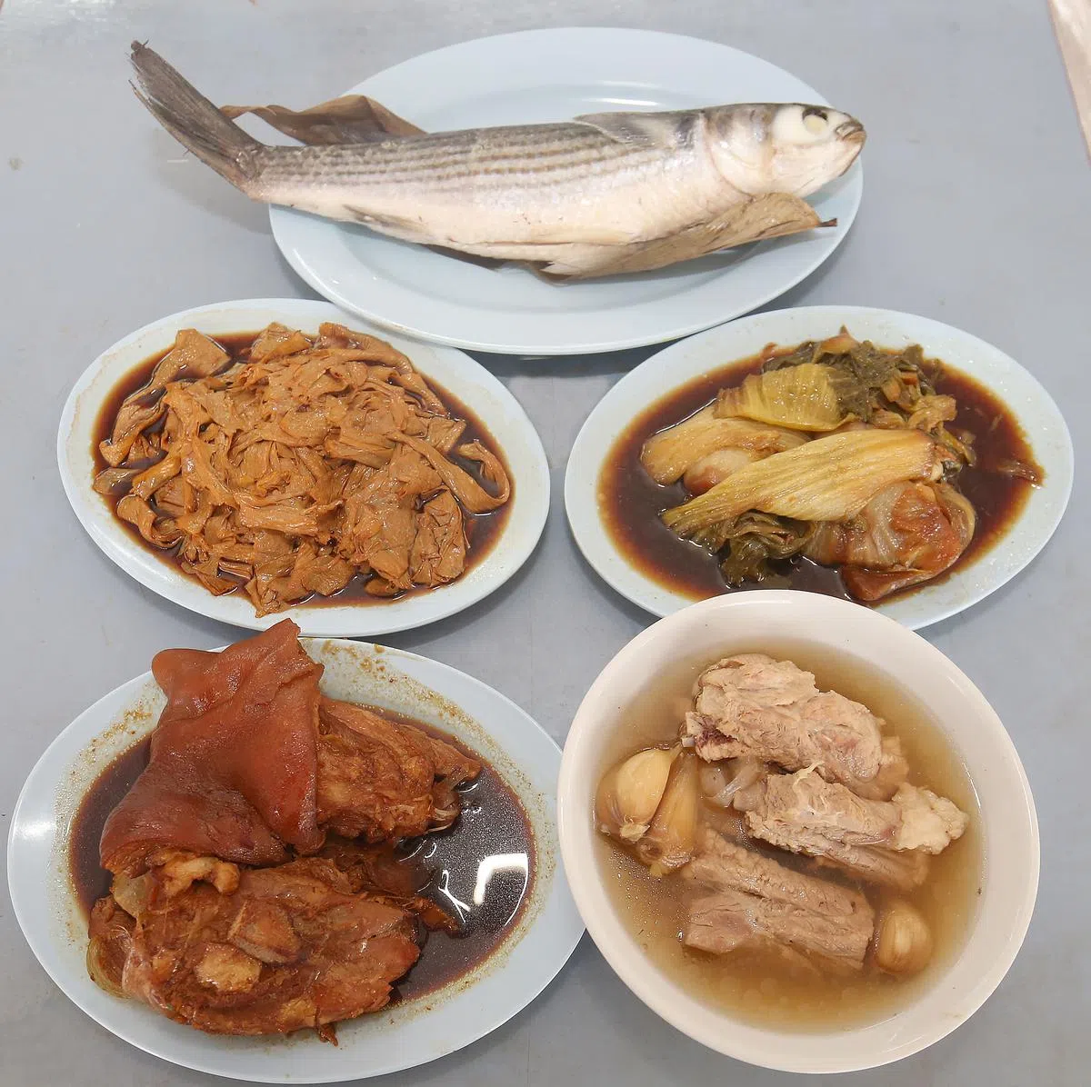 除了最有名的肉骨茶，也售卖卤猪脚、潮州蒸乌鱼，搭配着豆枝、芥菜等小菜。（邬福梁摄）