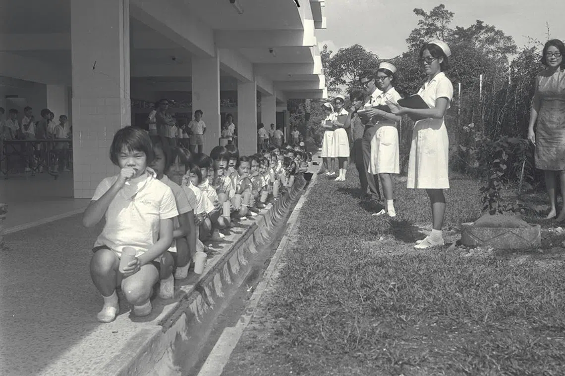 南侨女子学校1970年的刷牙比赛，学生一排排蹲在沟渠边刷牙，不论输赢，卫生习惯从小养成。（档案照）