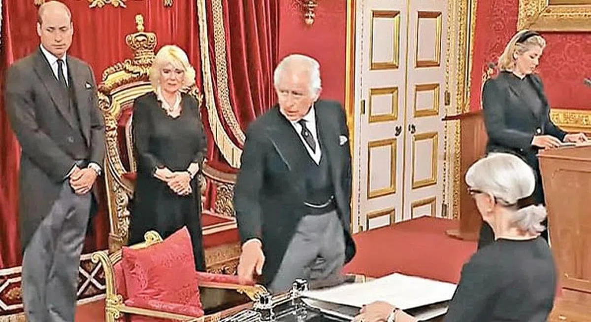 在电视转播的登基仪式中，可见新任国王查尔斯（中）不耐地向侍从示意，要求挪开笔盘。（互联网）