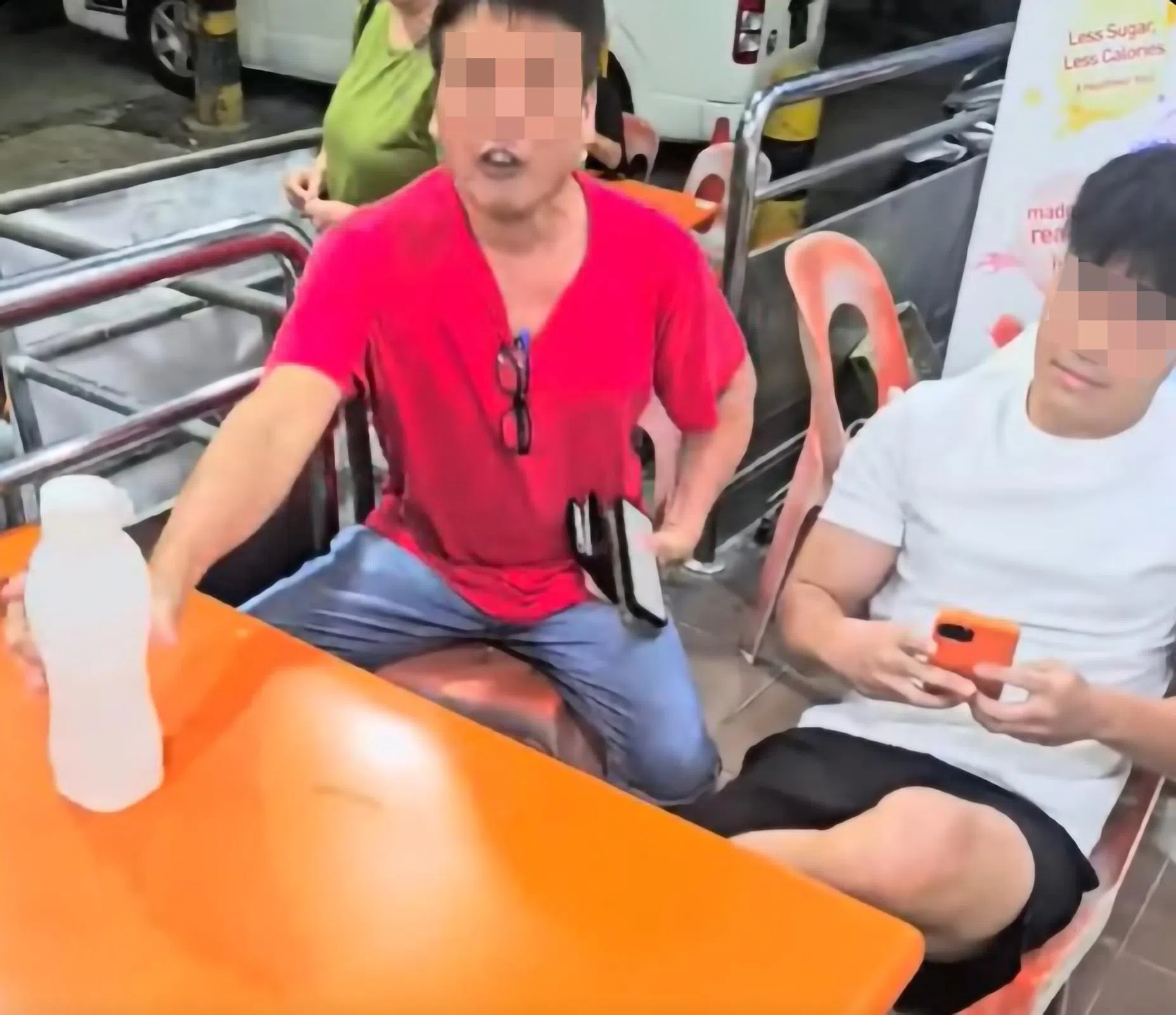 饮料摊主在社媒发布的视频显示，父亲（左）与镜头背后的摊主激烈争吵，情绪激动；儿子在一旁准备好手机，说就等摊主动手拍下视频为证。站在父亲背后的是这家人的母亲，过程中也插嘴表达不满。（受访摊主提供、视频截图）