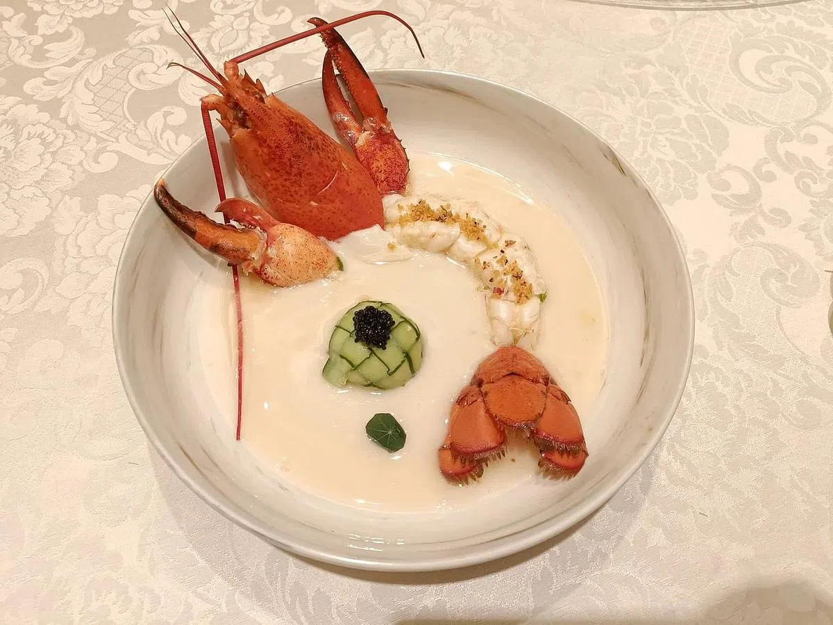 金牡丹餐馆的鸡油花雕龙虾，蟹肉球上缀以植物鱼子酱。（黄亿敏摄）