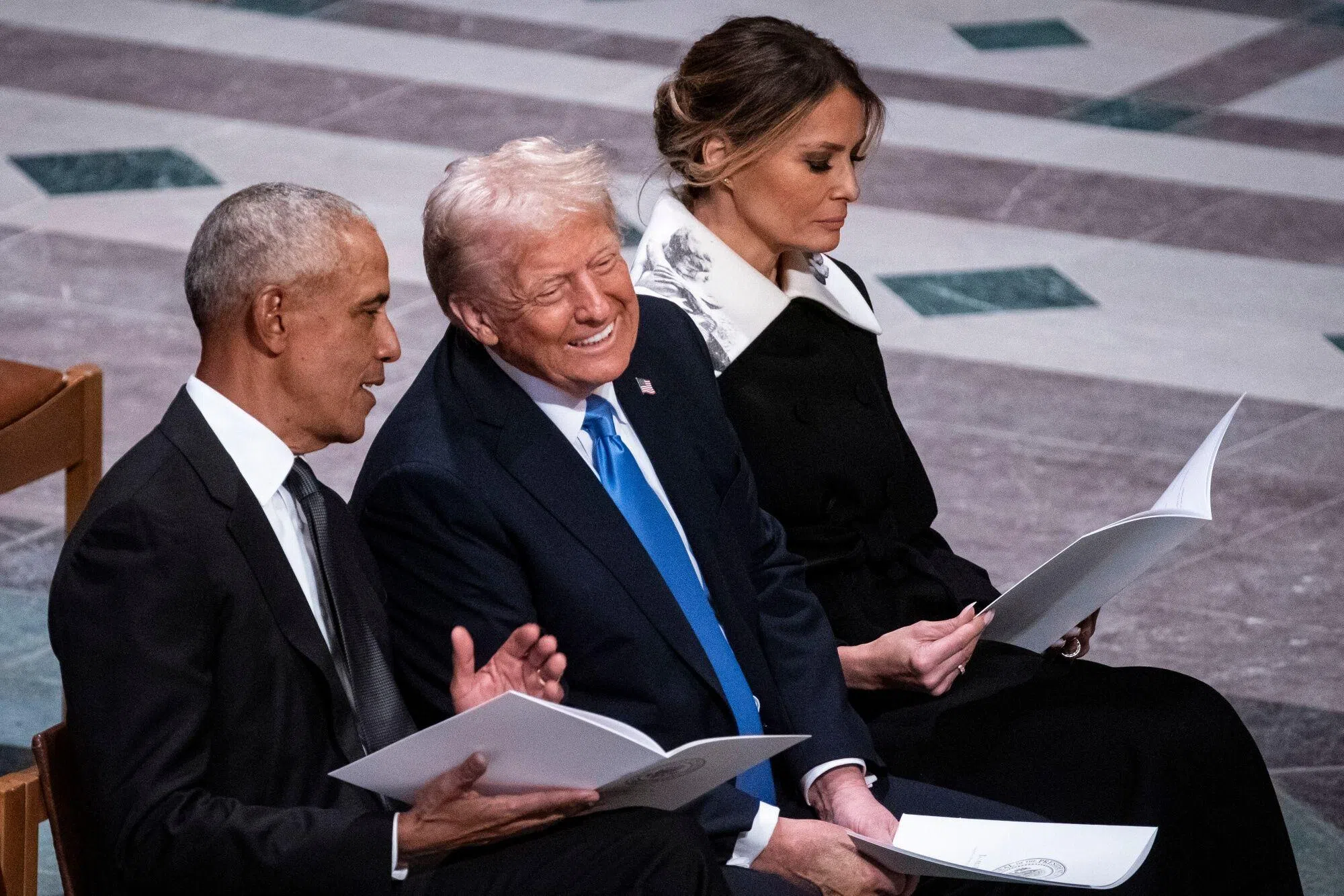 在卡特的国葬仪式开始前，特朗普（中）和奥巴马（左）交谈，有说有笑。（彭博社）