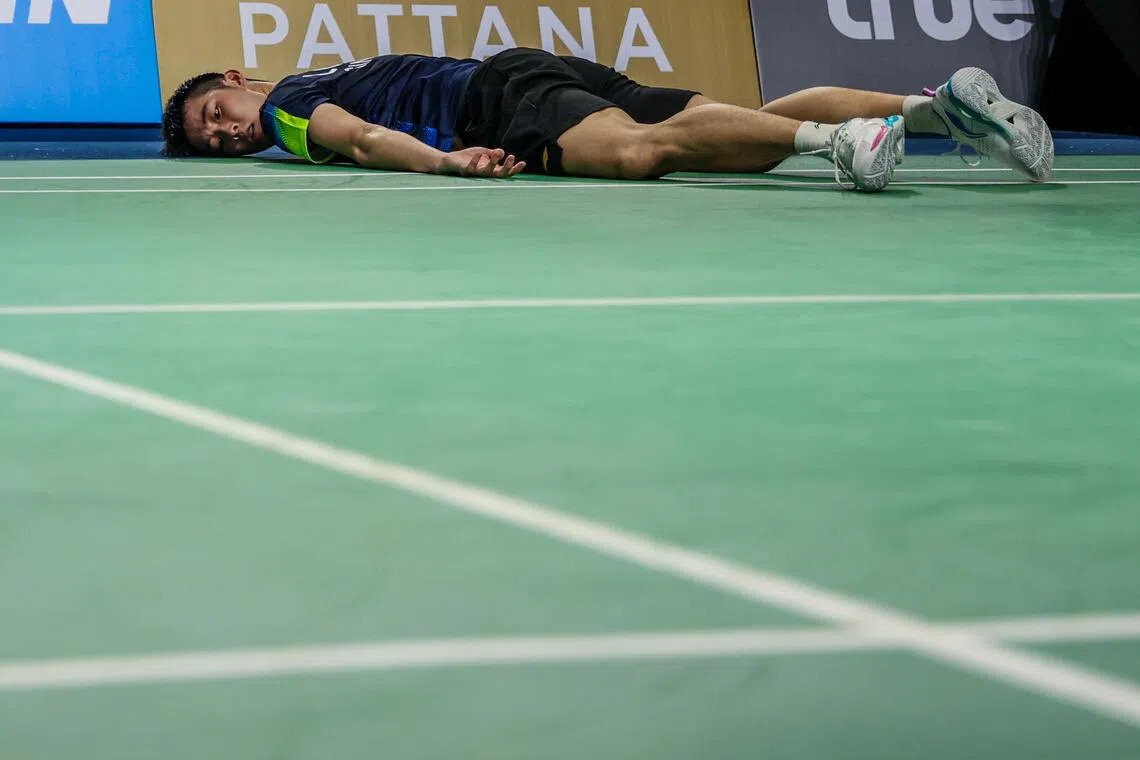 羽毛球健将骆建佑在比赛途中奋力救球，最终瘫倒在地。（白艳琳摄）