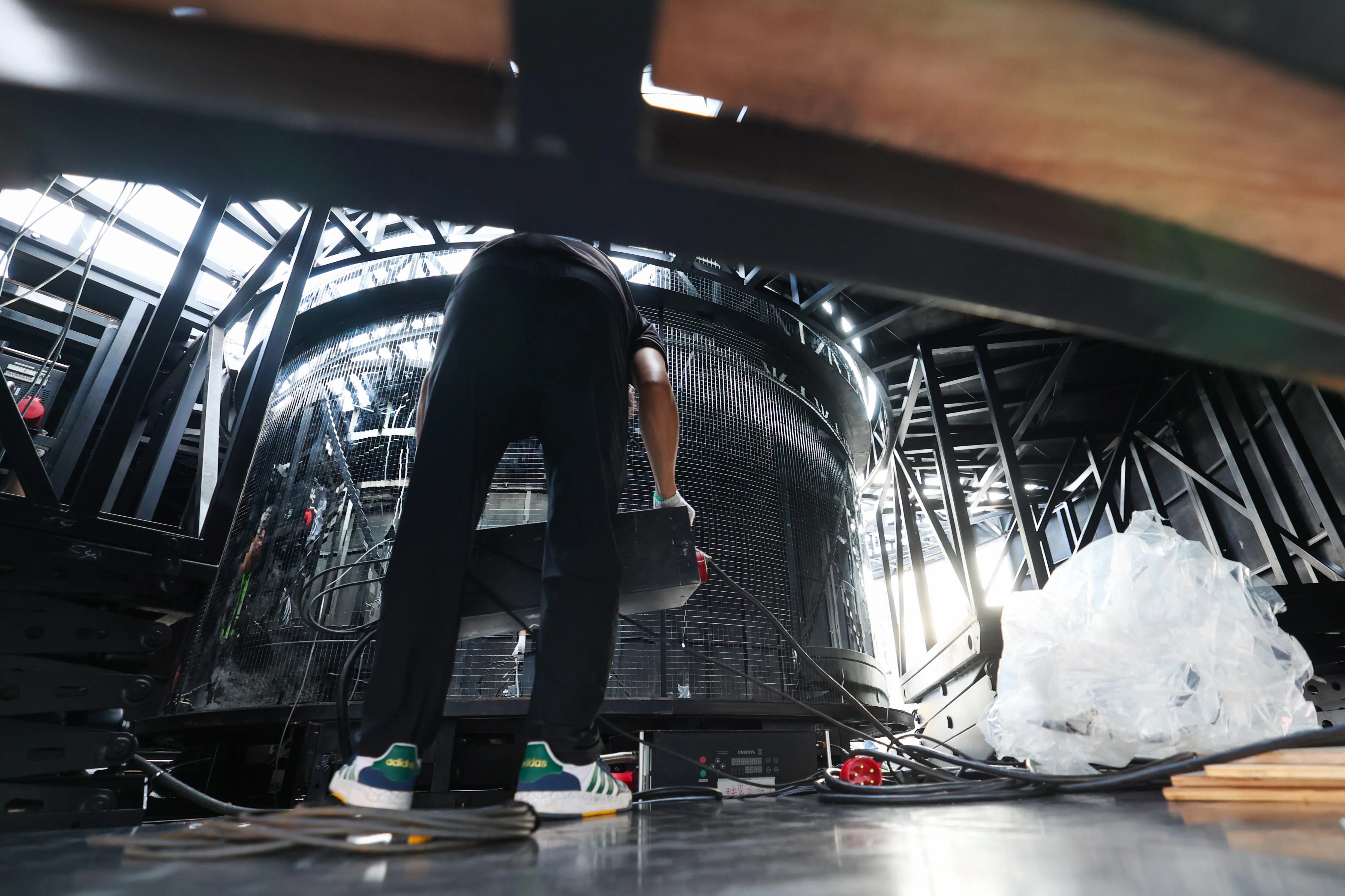 工作人员在舞台里进行电缆布线作业，他们一边理顺电缆，一边确保线路安全、整齐。（林明顺摄）