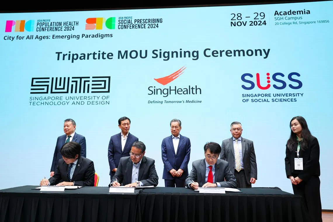 卫生部长王乙康（后排左二）星期四（11月28日）见证新保集团与新加坡社科大学和新加坡科技设计大学签署三方谅解备忘录。（林明顺摄）