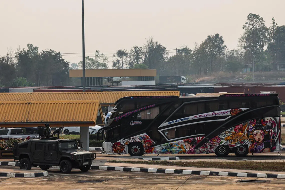 一辆载着缅甸电诈园区中国籍人员的巴士（右）星期四开抵泰缅友谊二号桥。这批人被送到湄索机场后，乘搭中国政府安排的包机回国。（路透社）