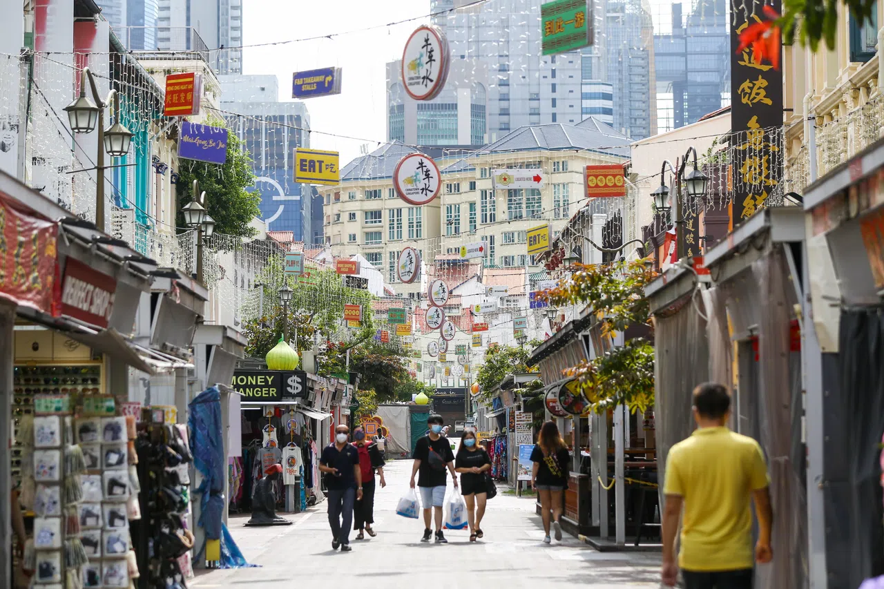 牛车水的街巷间游客摩肩接踵，餐馆的招牌五花八门。（白艳琳摄）
