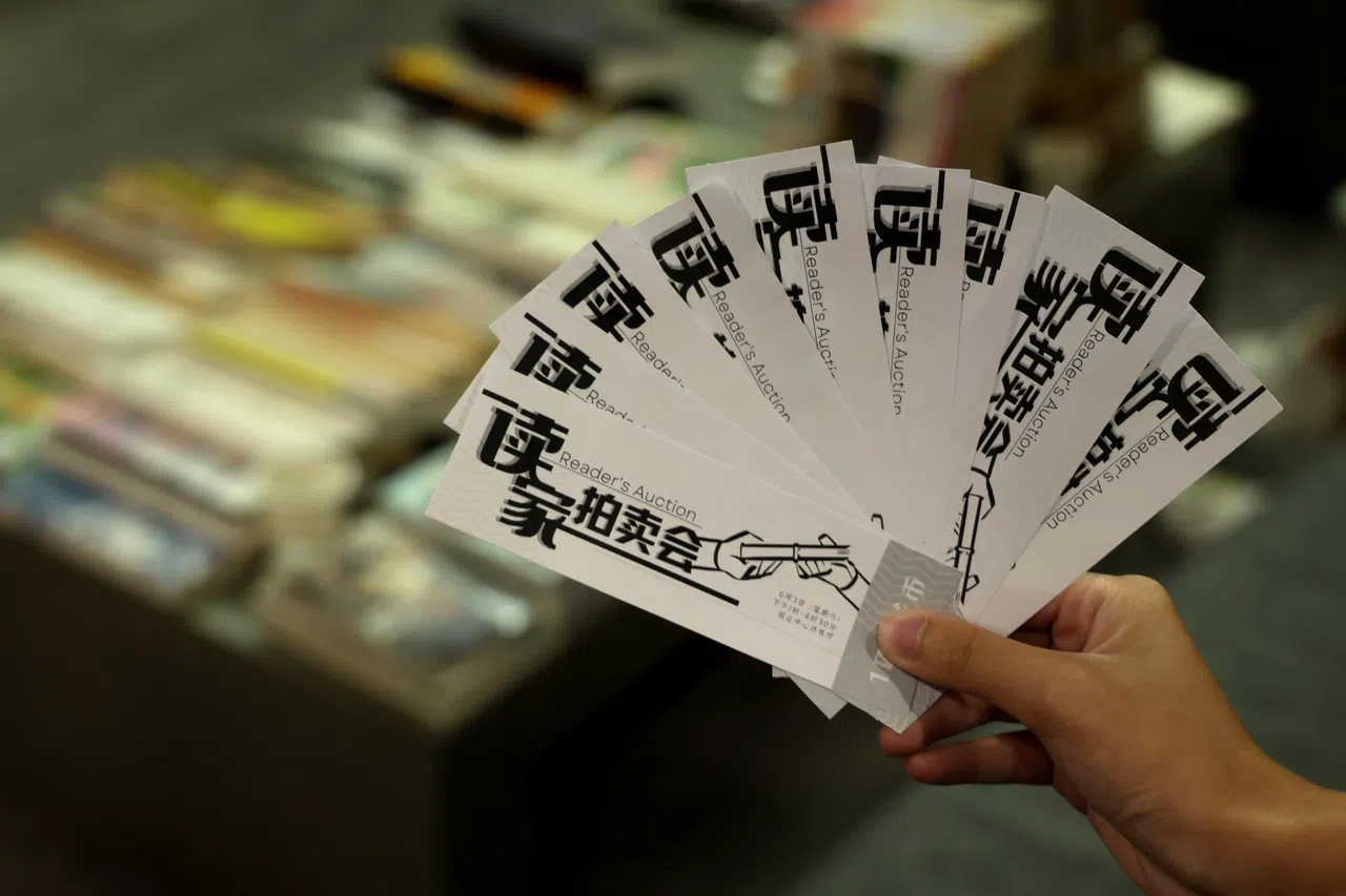 联合学生美术员陈敏怡为 “读家拍卖会”设计的拍卖专属百元书币。（龙国雄摄）