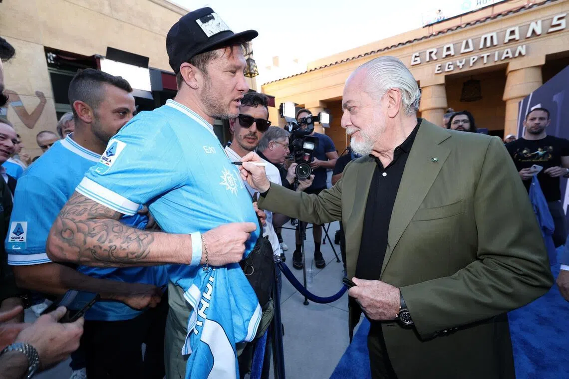 那波利主席德劳伦蒂斯（右）说，孔特若提出回国家队执教，他不会反对。图为德劳伦蒂斯在洛杉矶出席那波利四度夺冠纪录影片《4不可挡：那波利夺冠全纪实》的放映会时，为球迷签名留念。（路透社）