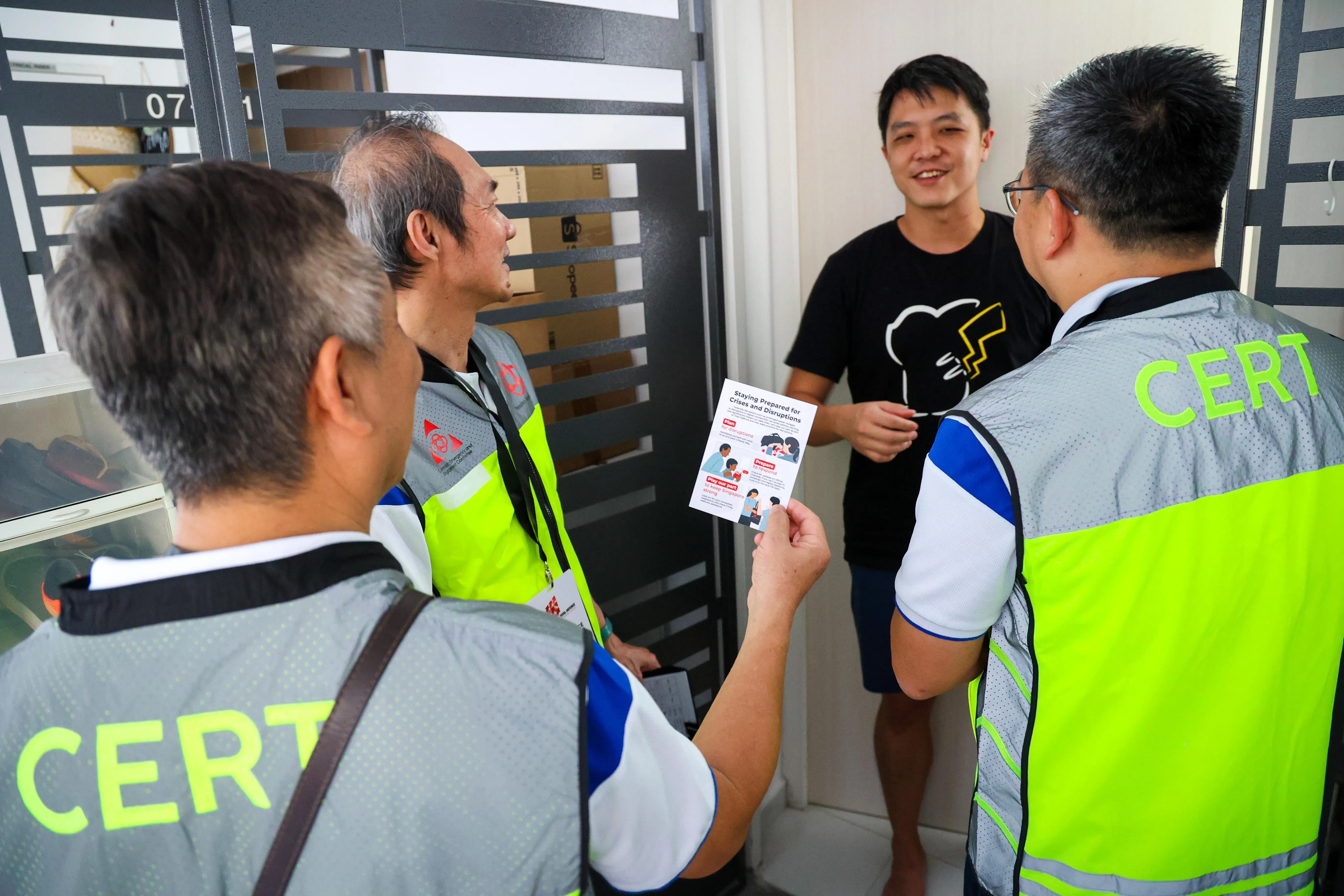 人民协会社区紧急应变小组的志愿者星期天到淡滨尼两座组屋向居民讲解，如何应对长时间停电和网络连接质量下降的情况。（林明顺摄）