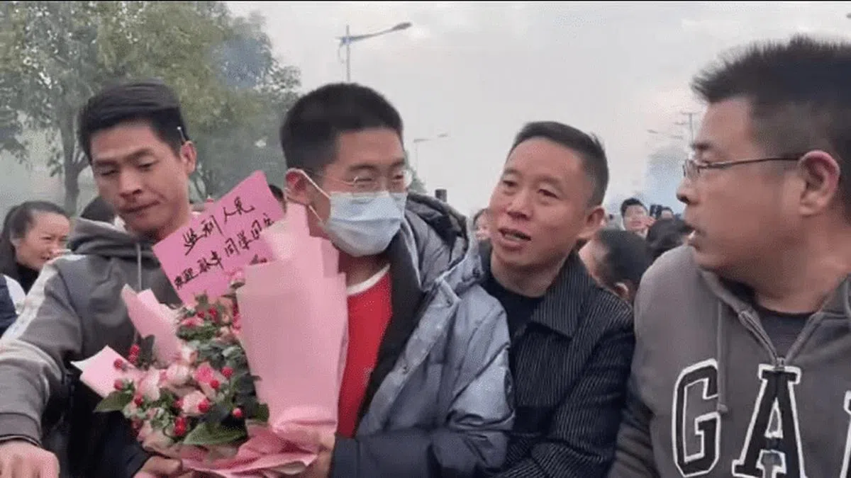 孙卓（中）与父母早前一起回湖北监利老家见亲人时，被当地许多民众围绕并拍照。（微博）