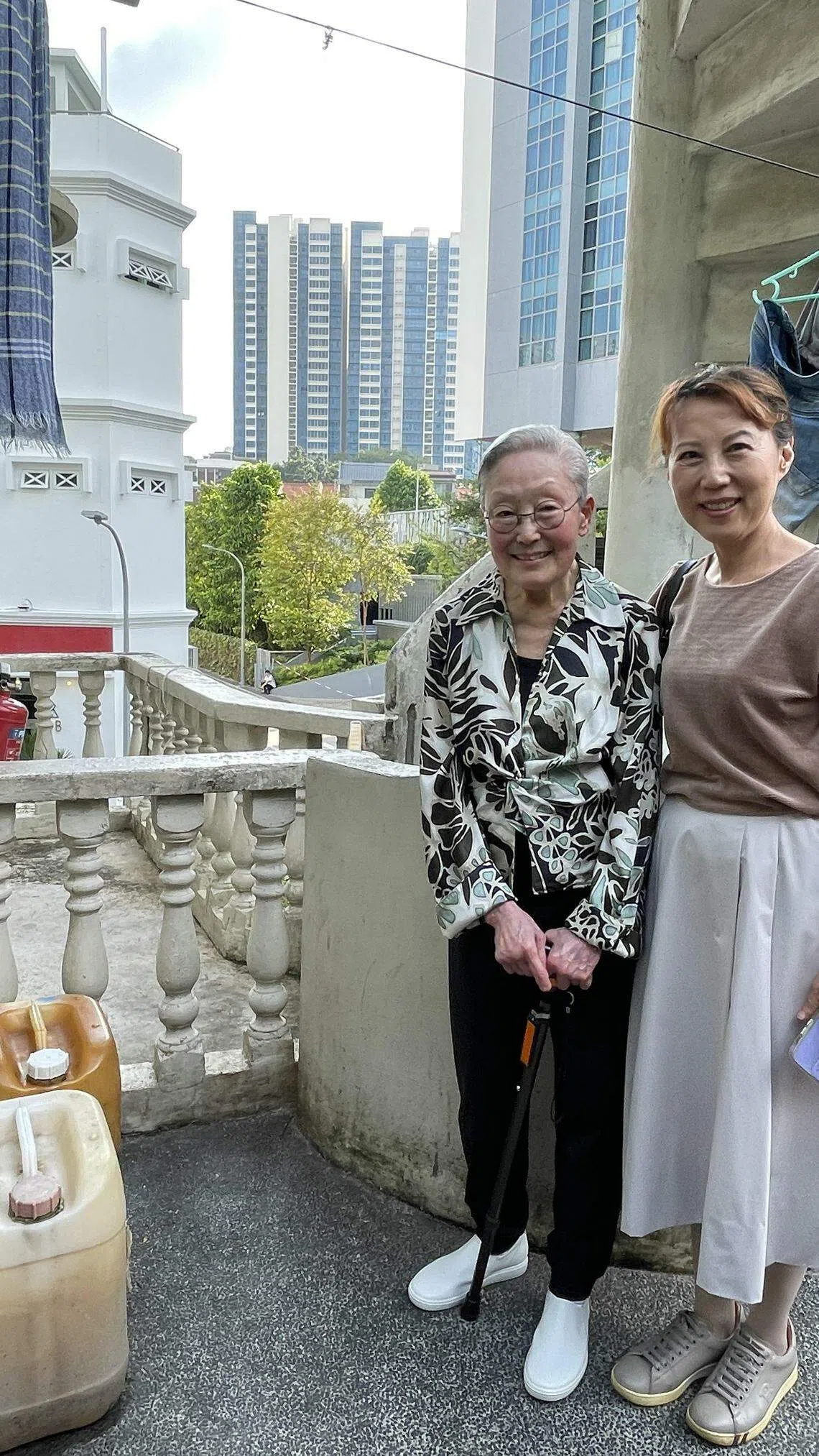 刘氏夫妇居住狮城的旧友章星虹（右）与刘太在我们以为是刘以鬯曾住过的边间房阳台外合影。（林方伟摄）