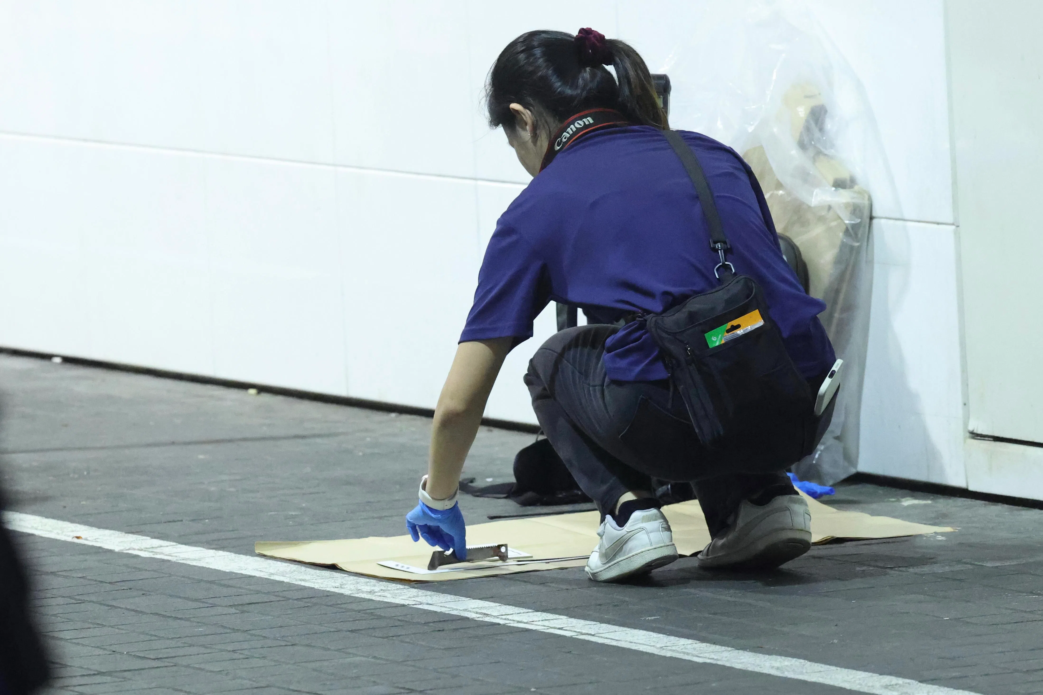 警方现场取证一把疑似带血的利器。（郑一鸣摄）
