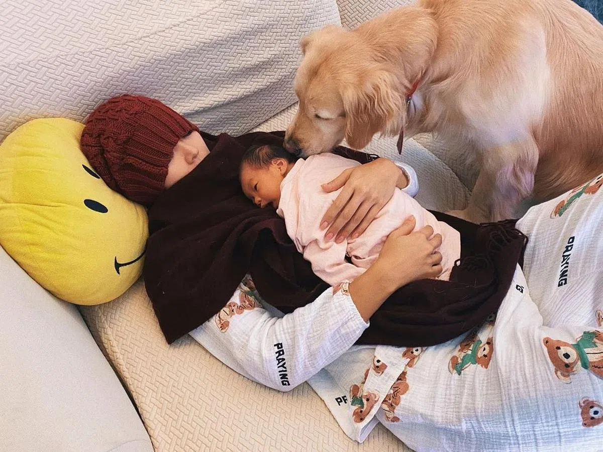 梁诺妍抱着女儿与狗睡觉。（IG）
