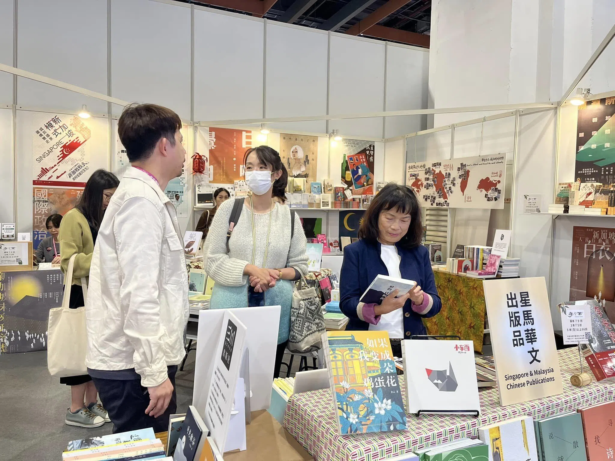 2024年台北国际书展期间，台湾作家龙应台（右一）正好来到季风带文化展摊，翻阅新马作品。（档案照）