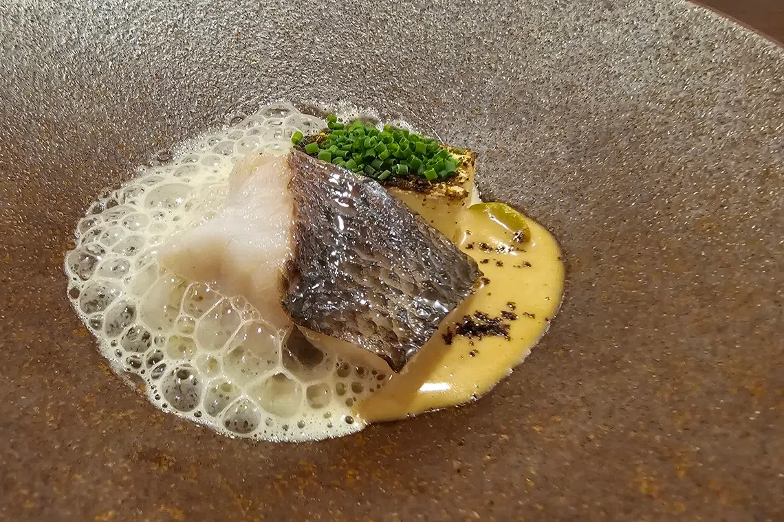 蒸鱼的灵感，来自卓均仰小时候吃过的XO鱼头米粉。他以鱼骨高汤和VSOP干邑白兰地制成的奶泡，画龙点睛。（黄亿敏摄）