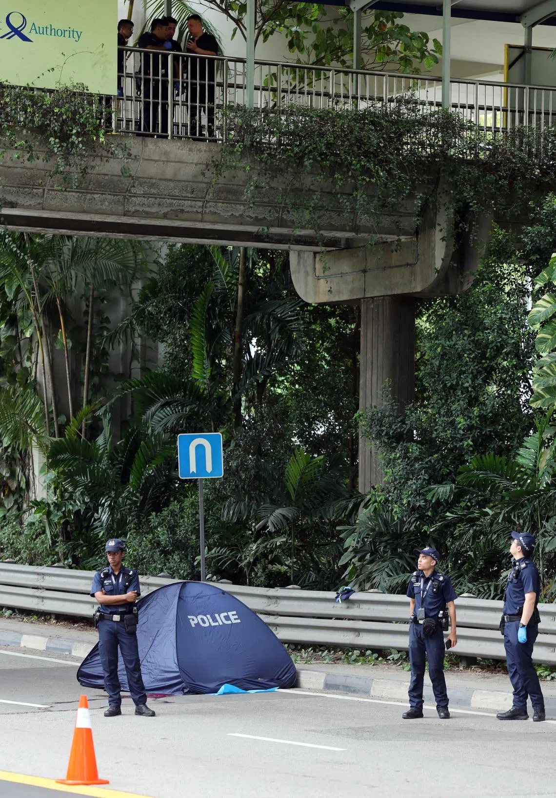 警方在天桥上进行调查，并取走一个相信属于死者的行李箱。（邝启聪摄）