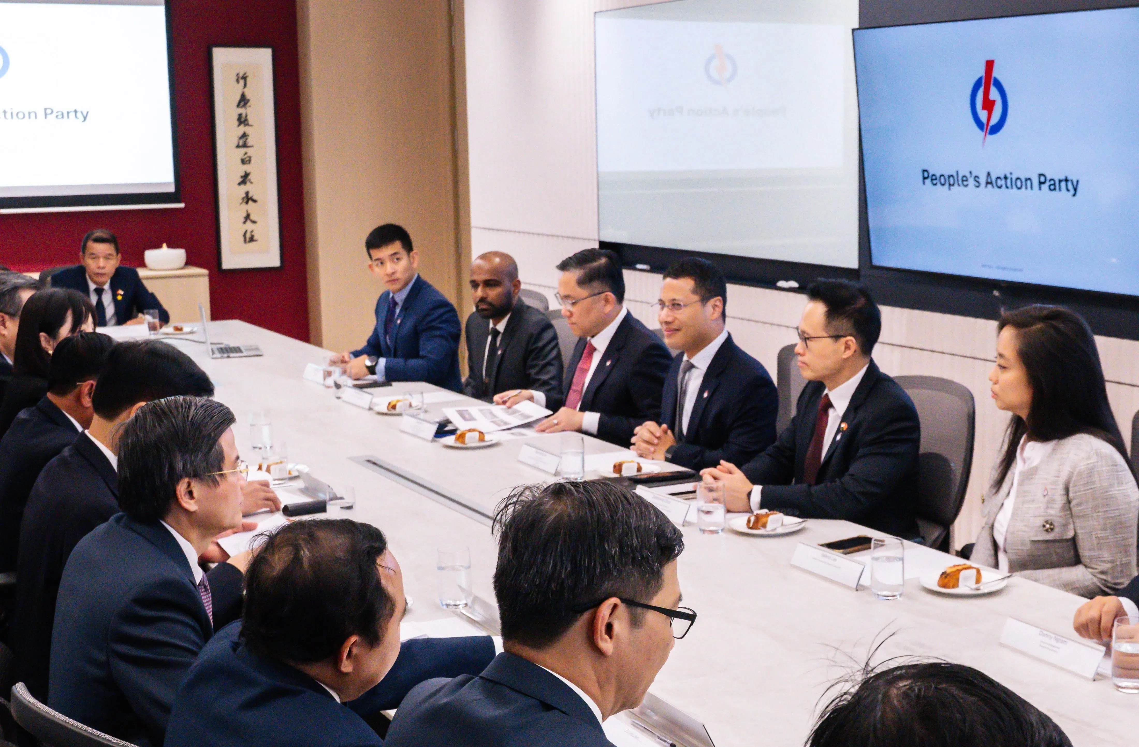 人民行动党主席李智陞（右三）偕行动党党员（右起）李乃怡、朱倍庆、任梓铭和贺明医生，与越共代表团交流。（人民行动党提供）