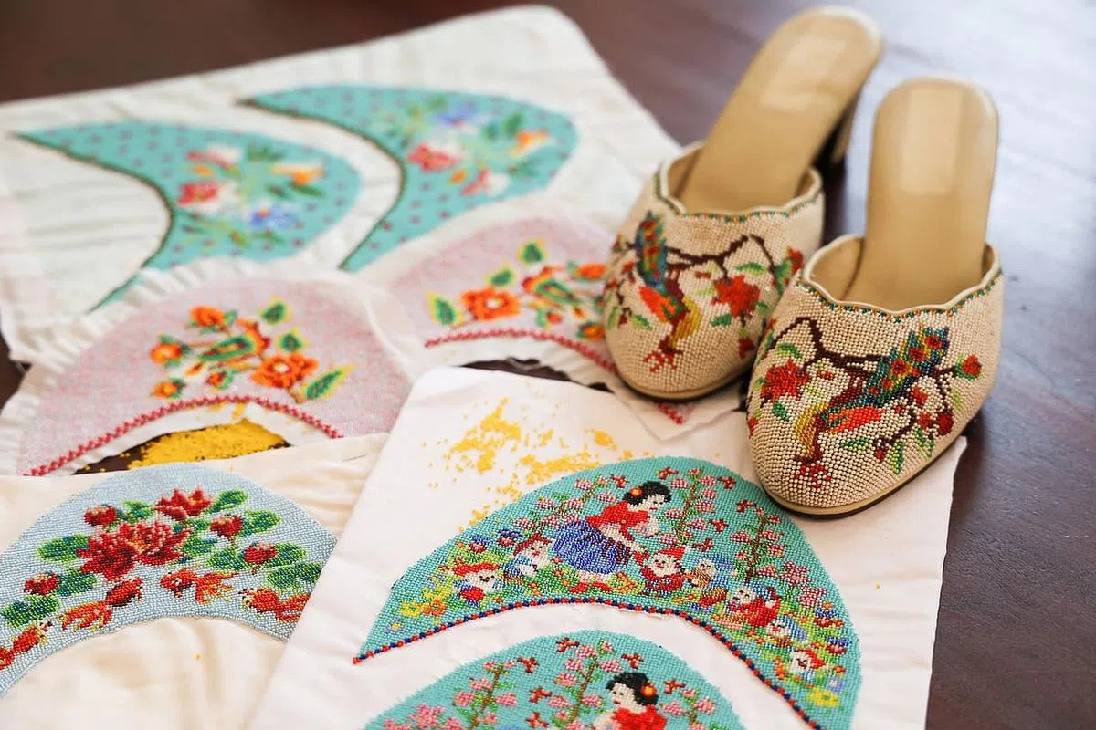 白雪公主与七小矮人的图案是黄俊荣根据一双老珠绣鞋面的金发姑娘和天鹅图样改良的。（蔡家增摄）