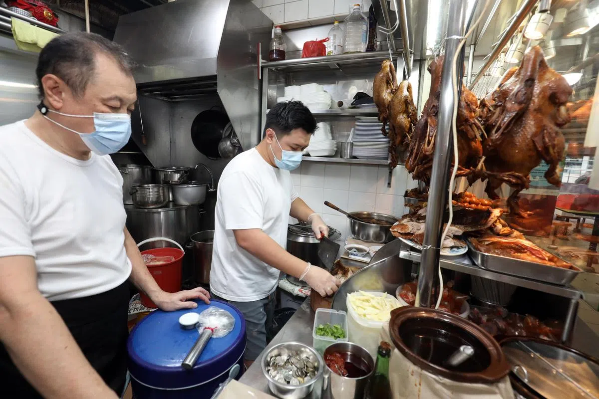 从准备工作到砍鸭，张俊国在爸爸短暂休息时参与更多档口工作。（摄影/邝启聪）