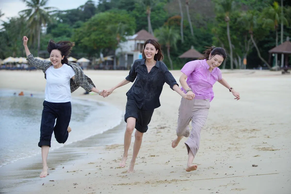 三位“丽娇”赤脚在海滩上奔跑。（谢智扬摄）