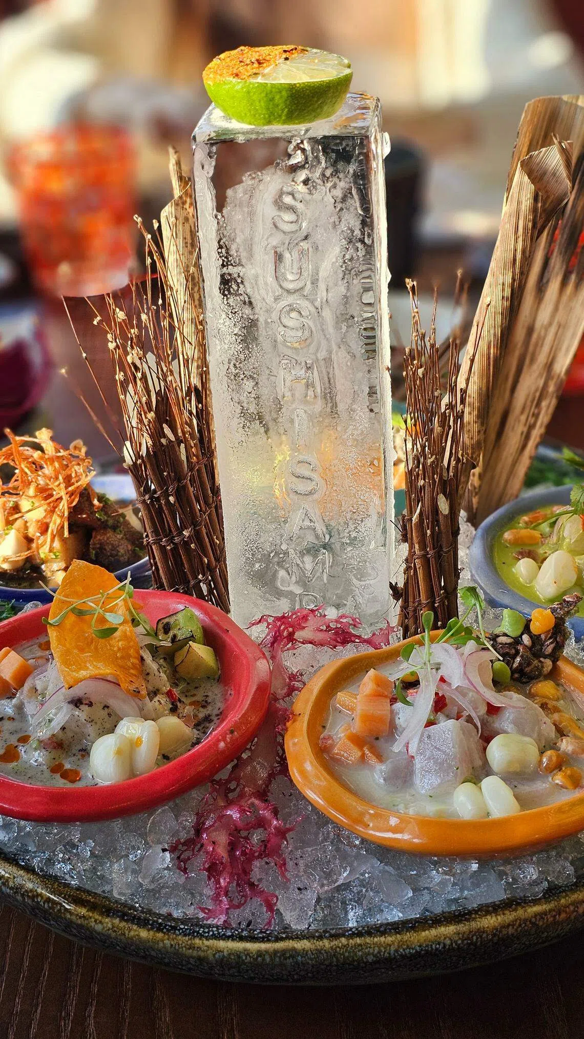 秘鲁腌鱼生拼盘，有五种不同调料口味，摆盘也漂亮，中间的长冰块代表餐馆所处的高楼大厦。（黄亿敏摄）